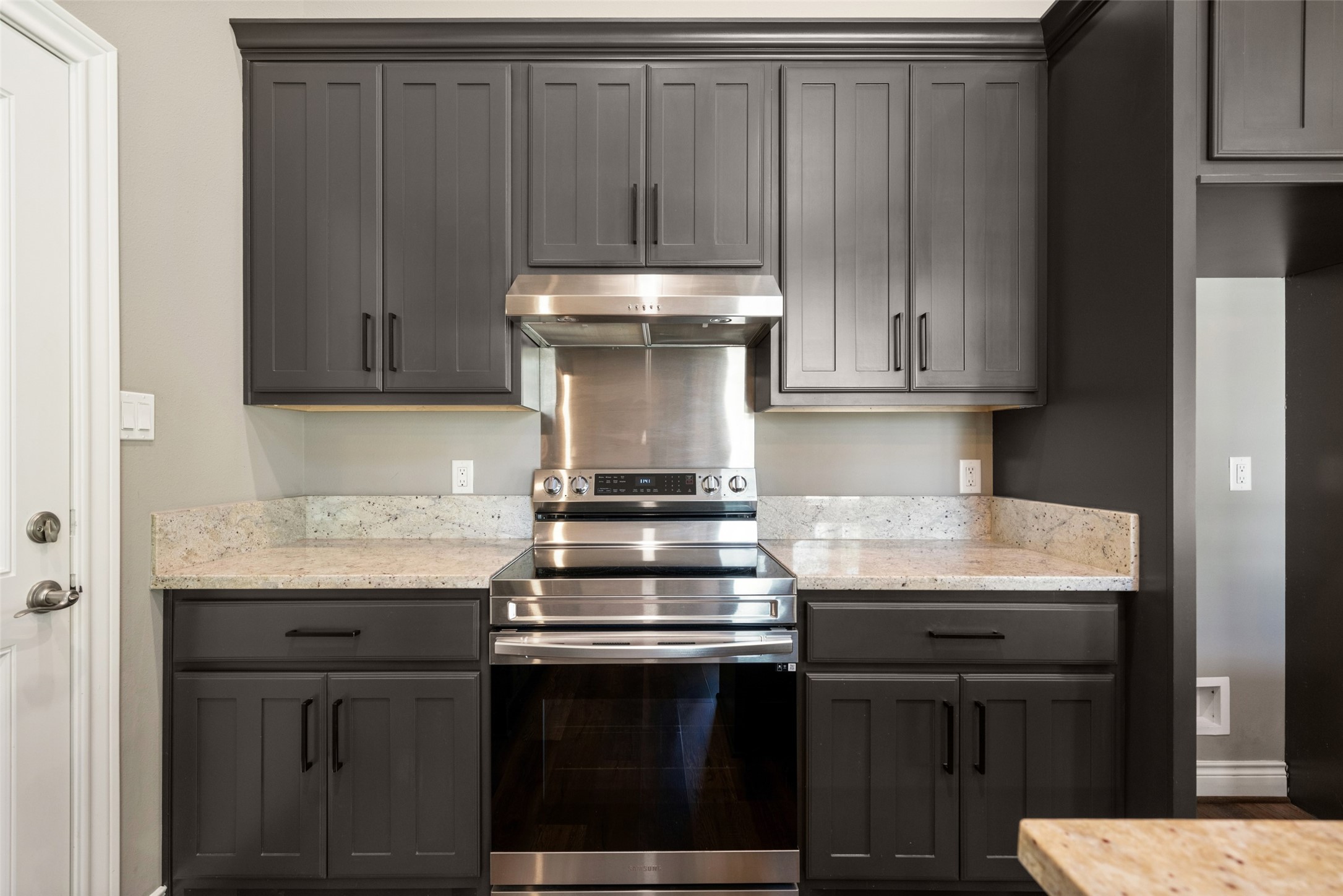 Kitchen featuring white cabinetry, a stainless steel range and vent hood, tile backsplash, and a window above the sink.