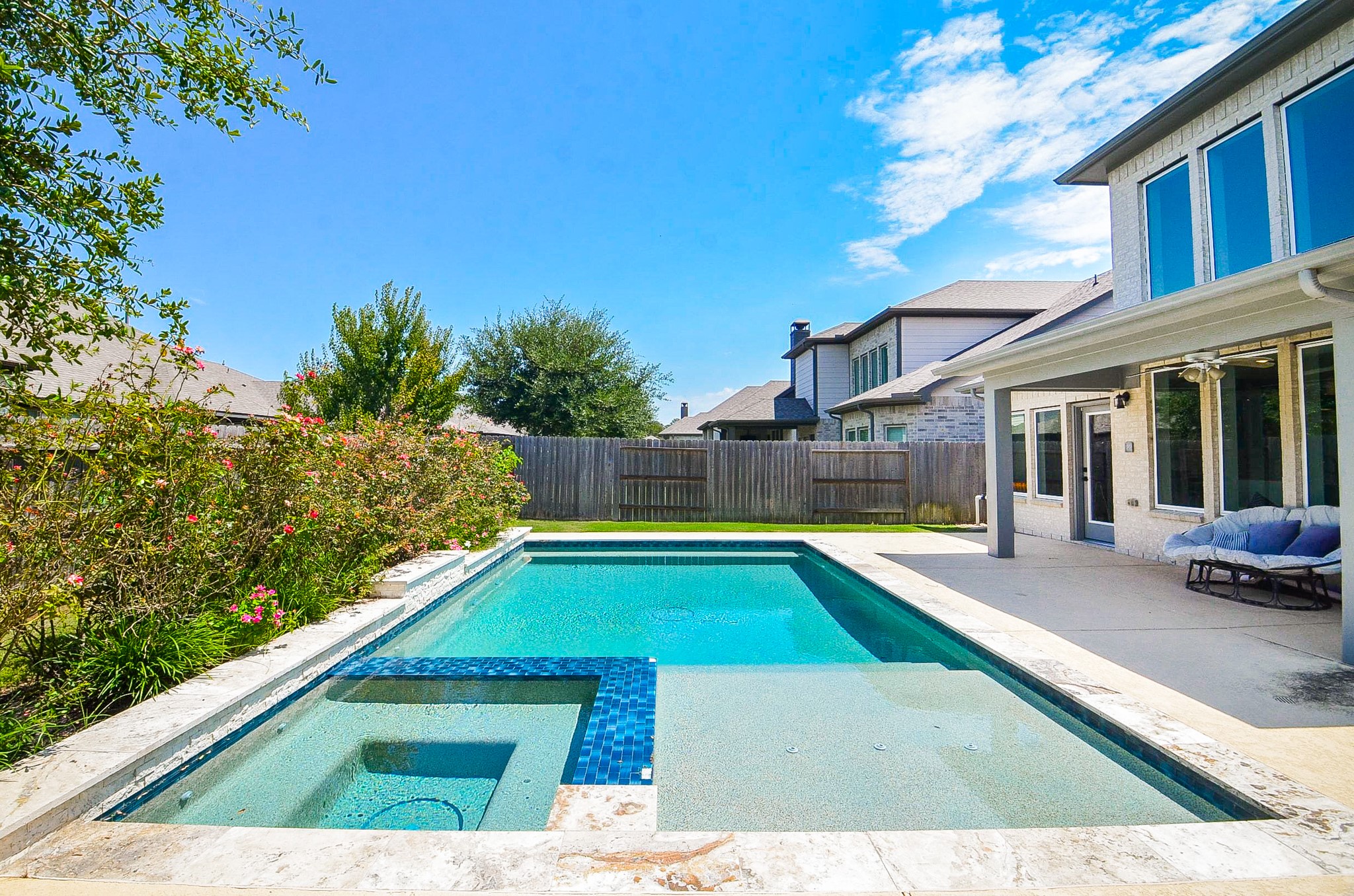 Experience outdoor luxury with this stunning backyard featuring a sparkling pool, spa, and spacious patio, perfect for relaxation and entertaining.