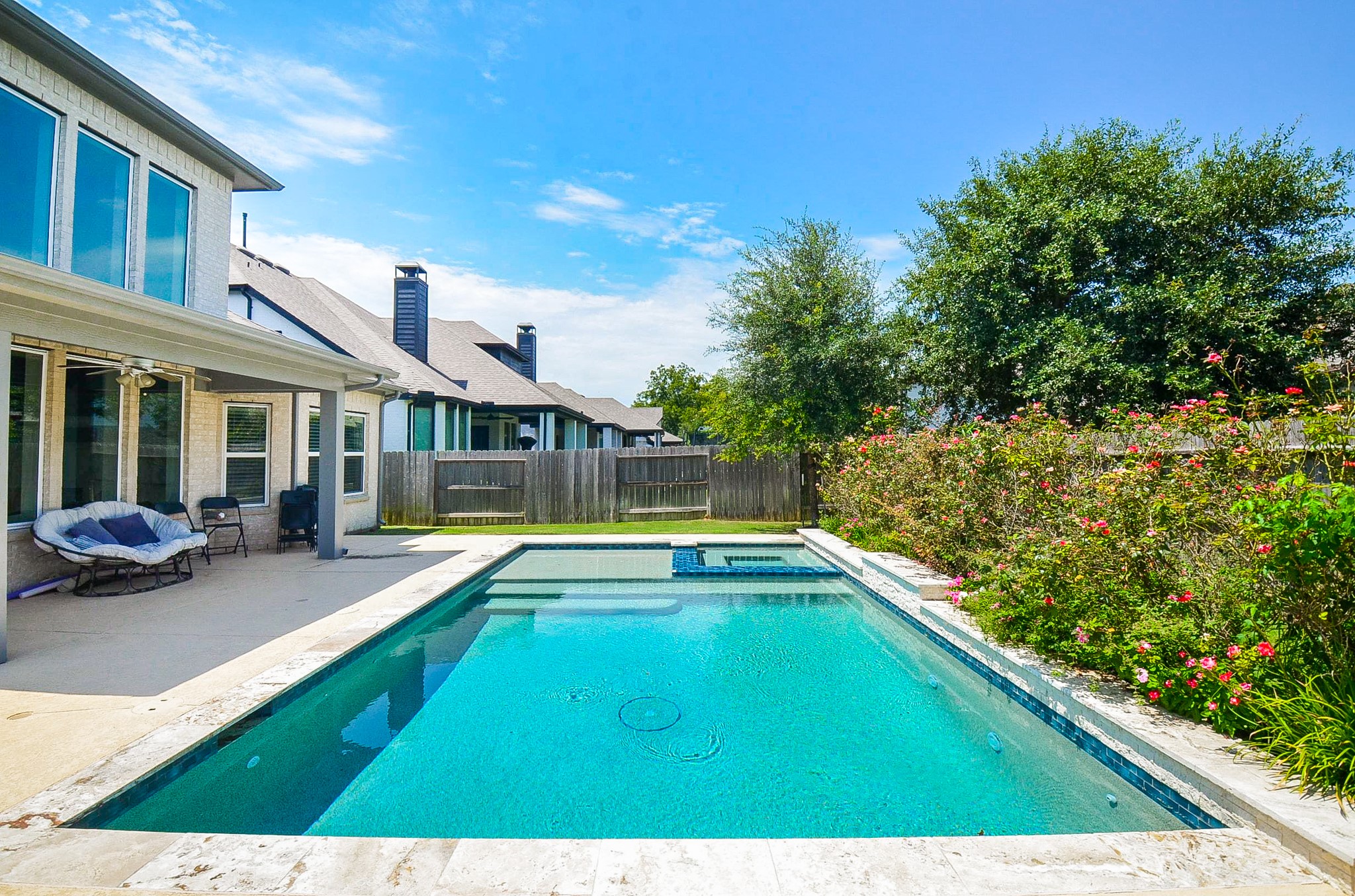 Enjoy a refreshing oasis in your own backyard with this stunning pool, surrounded by lush greenery and a spacious patio perfect for relaxation and entertaining.