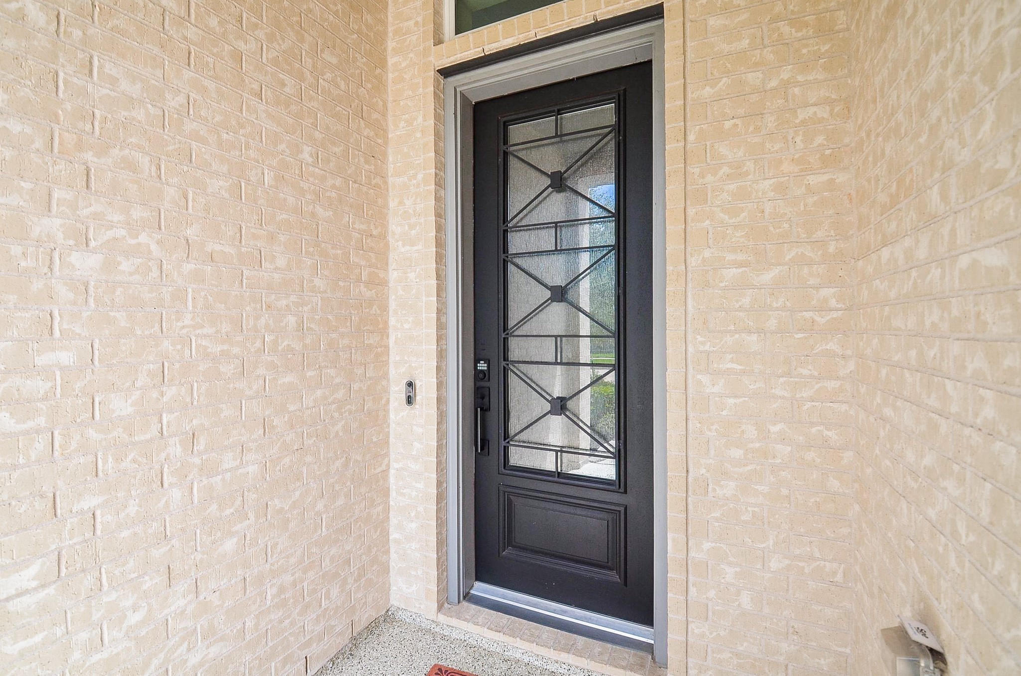 Elegant brick entryway featuring a striking black door with decorative glass, offering a welcoming and secure entrance. Elegant brick entryway featuring a striking black door with decorative glass, offering a welcoming and secure entrance.
