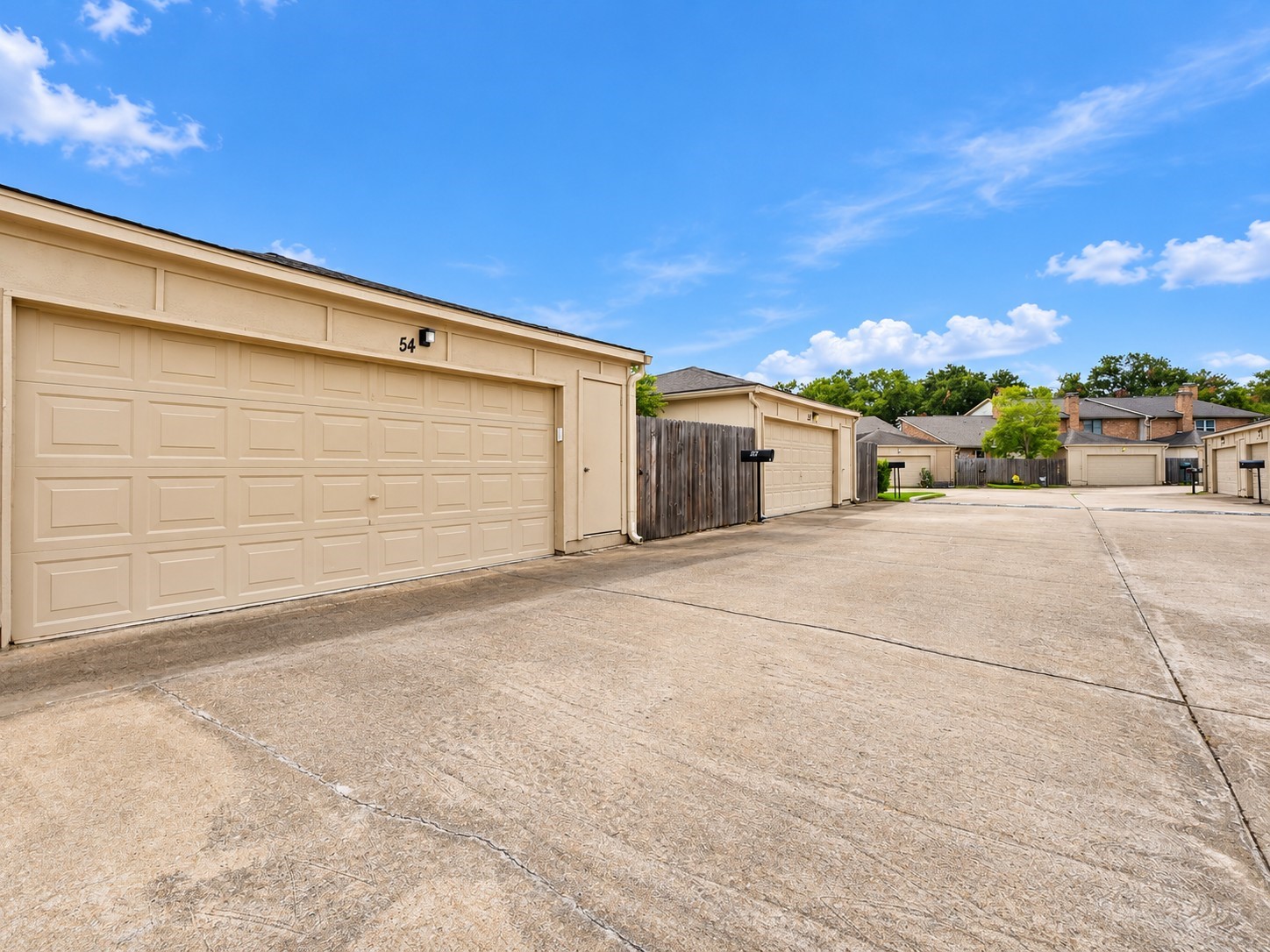 54 T Huxley Ln has a spacious 2 car garage, fenced in patio w/gate, & trash can storage.