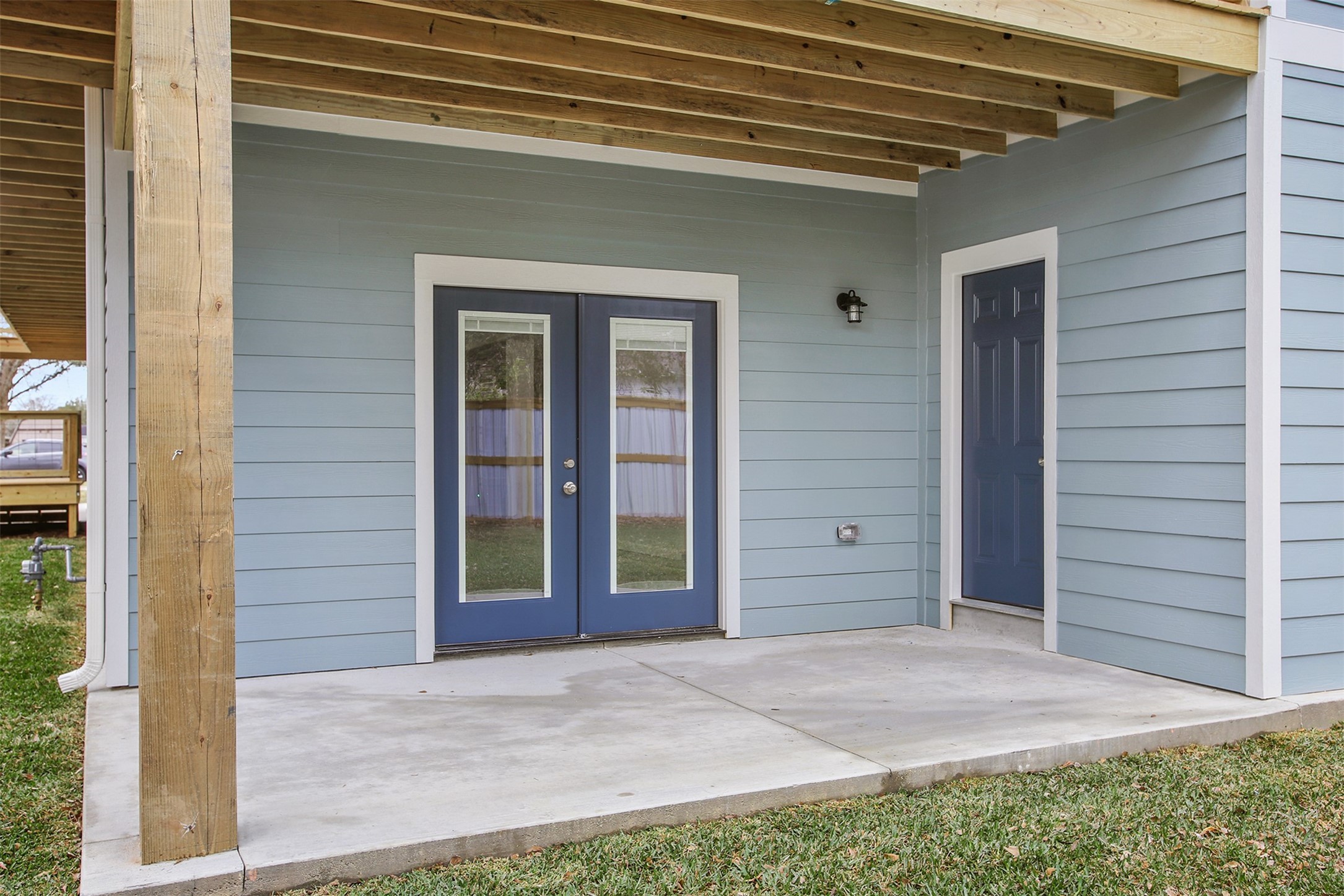 Downstairs back patio with french doors to the garage and door to the downstairs bathroom