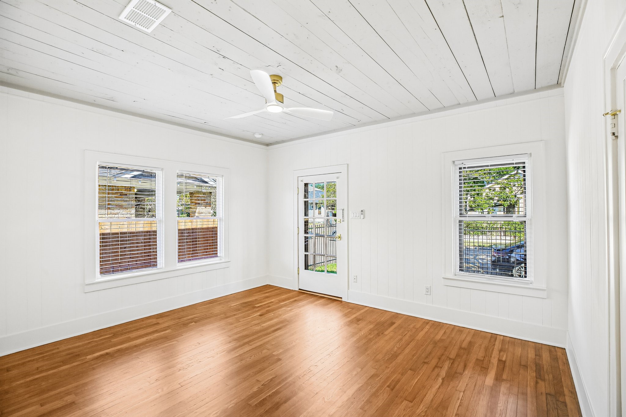 The spacious living room features painted shiplap ceilings and gorgous newly refinished oak floors.