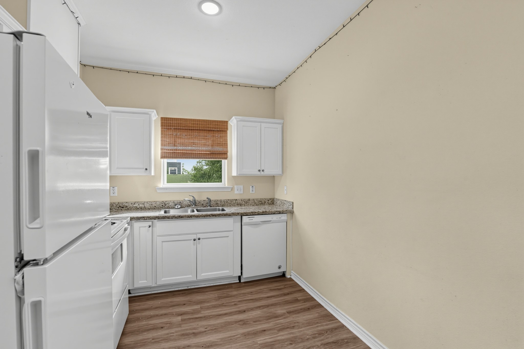 Kitchen has ample cabinet space, natural light, and a stainless steel sink.
