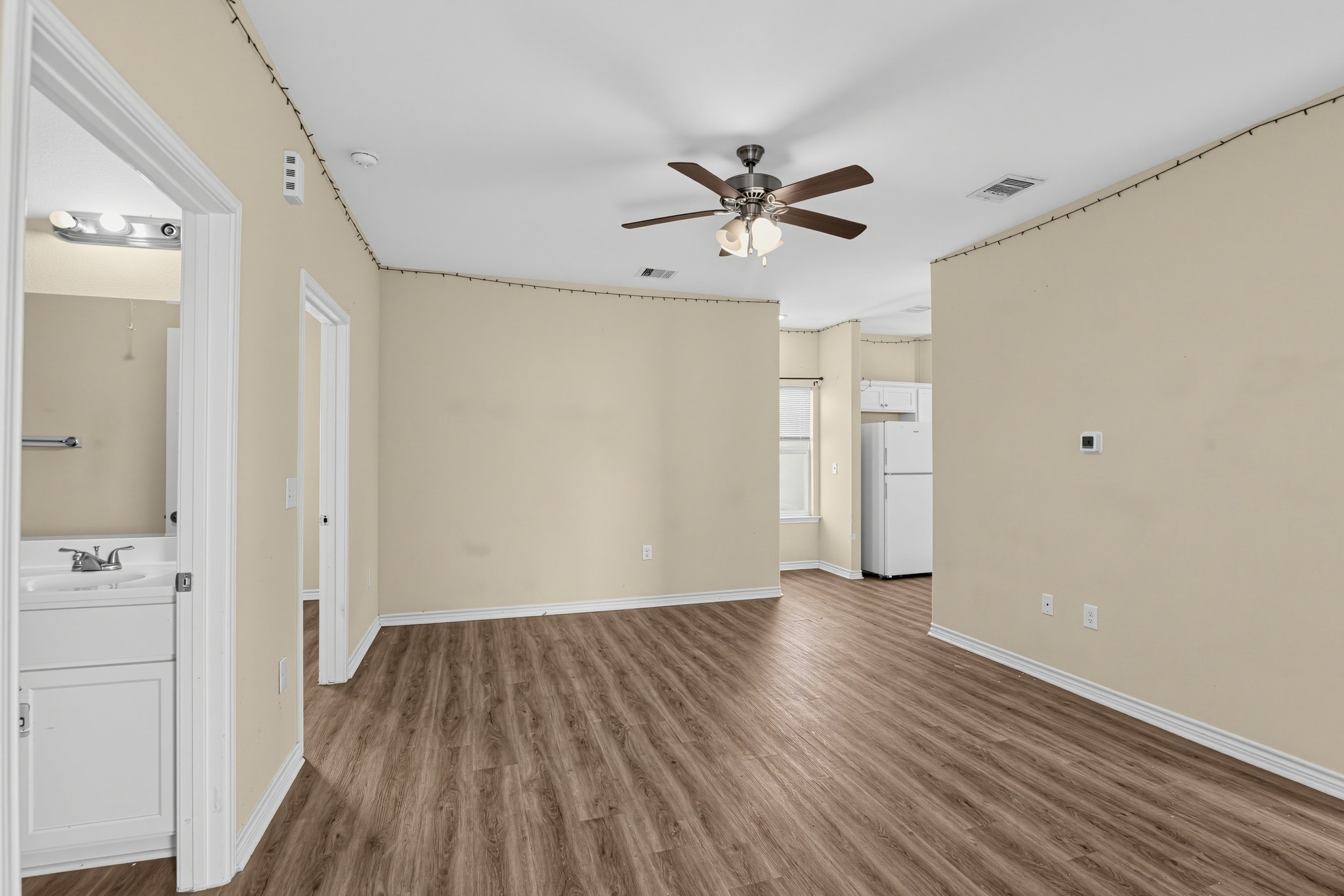 A spacious family room offering a seamless view into the kitchen entryway.