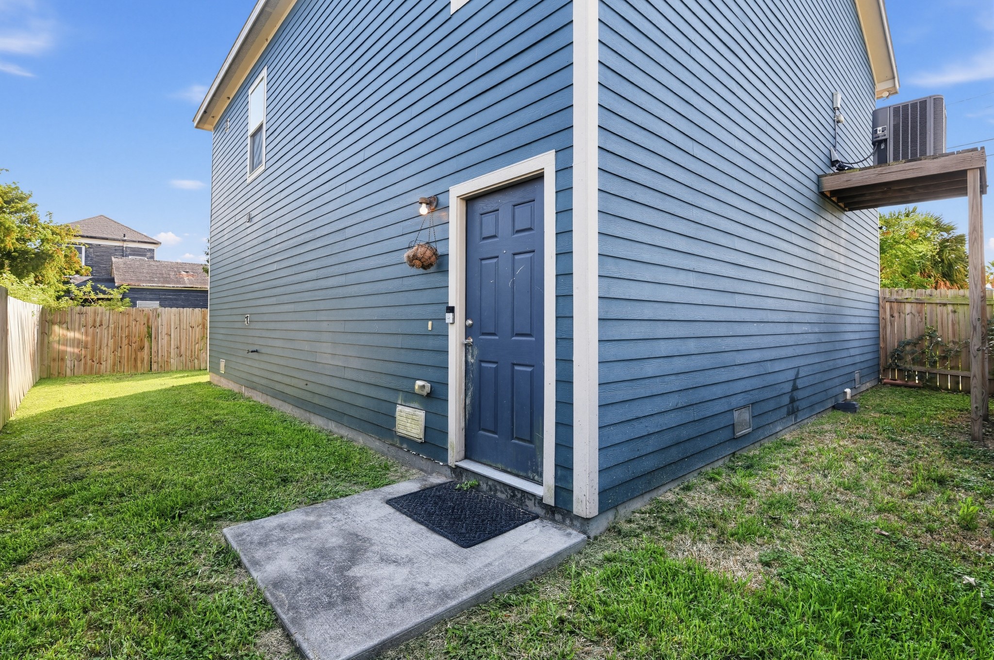 Back of the home with entry door. Elevated AC compressor.