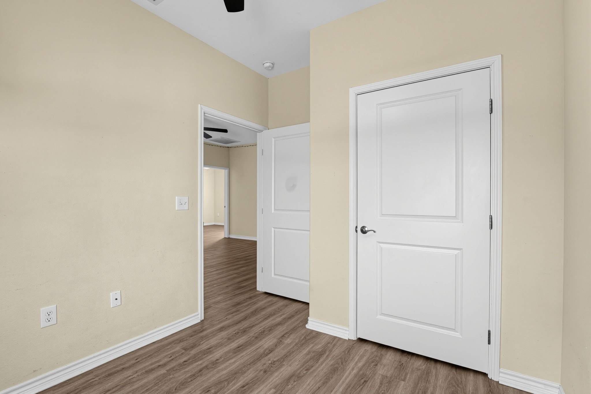 Bedroom with ceiling fan and light fixture.