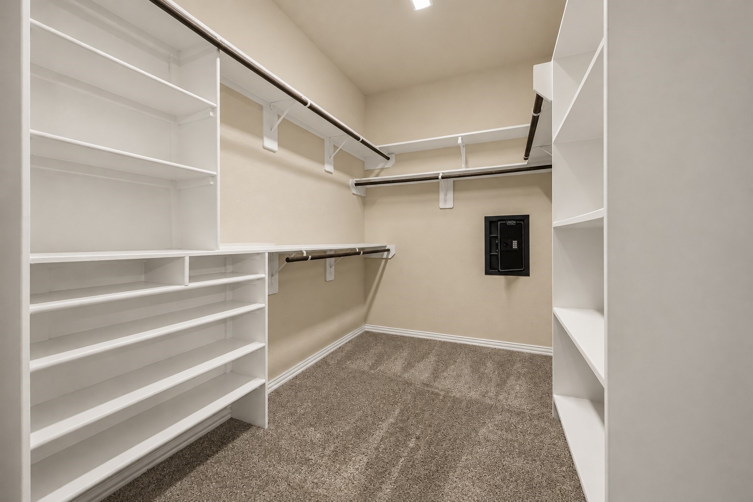 Spacious primary walk-in closet with built-in shelving, abundant storage, and a wall safe for added security!