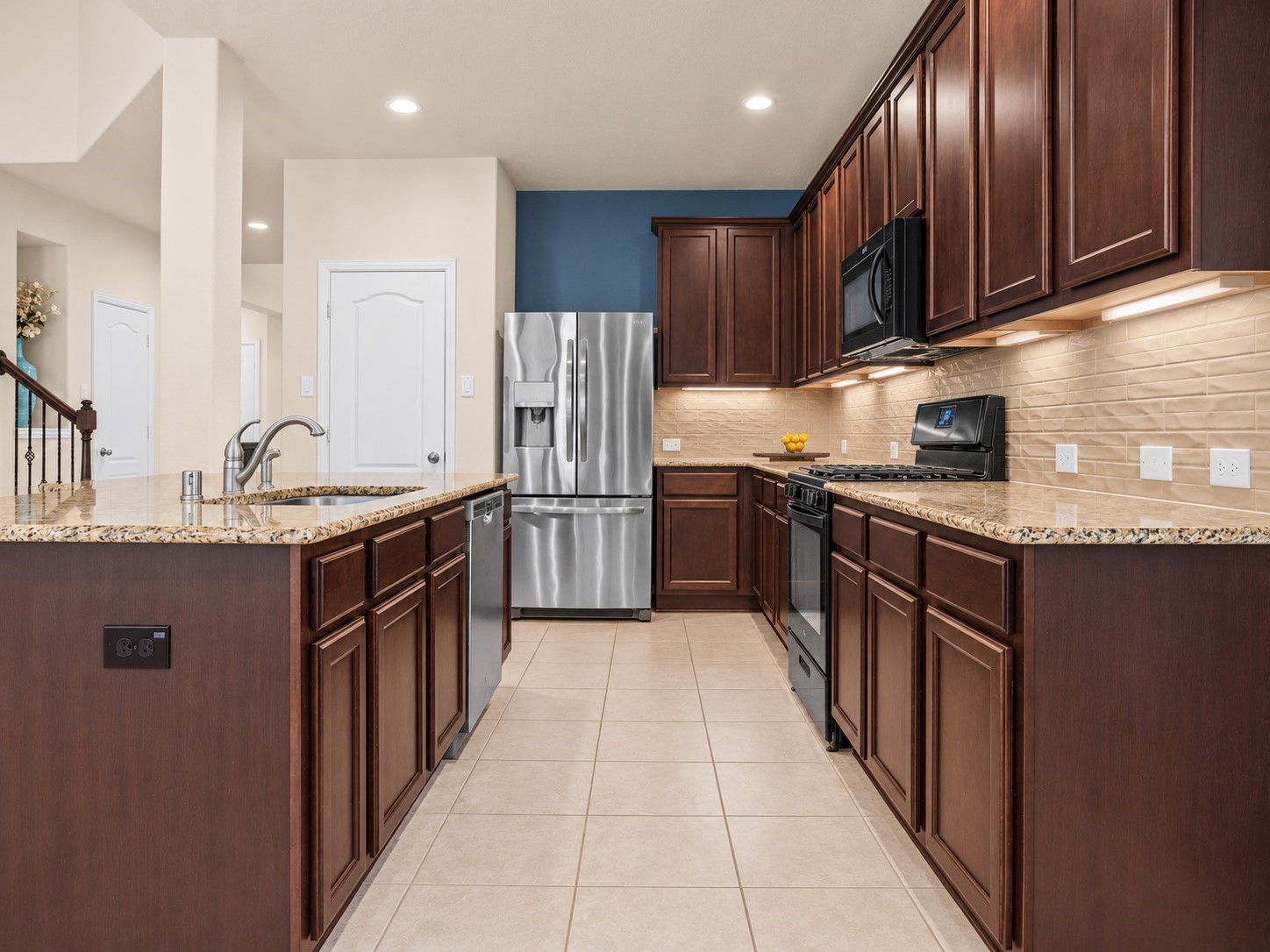 A kitchen designed to impress! Featuring rich cabinetry, granite countertops, gas cooking, and under-cabinet lighting, with generous storage and prep space to make everyday cooking and entertaining a pleasure!