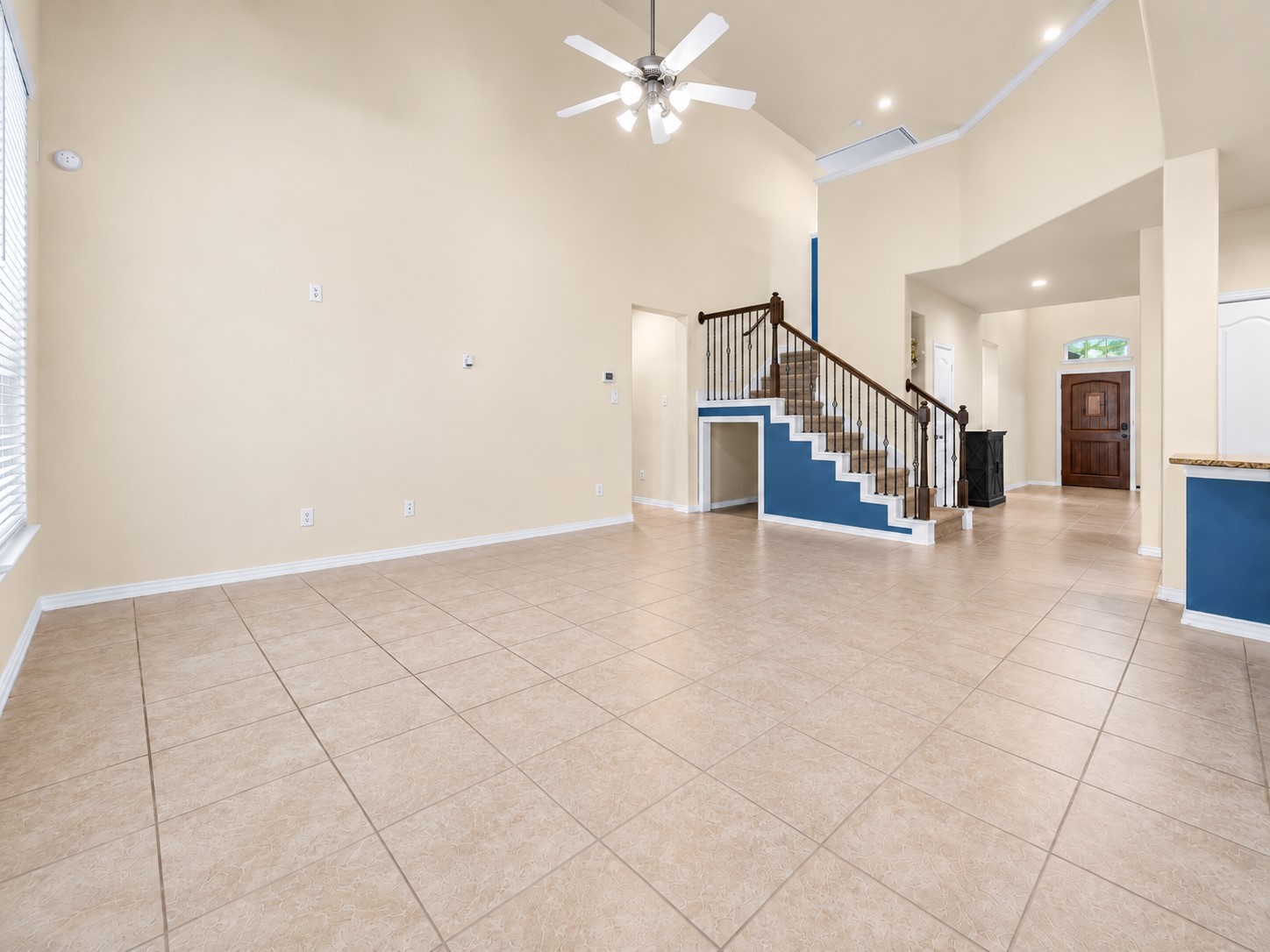 Feel right at home in this family room - featuring soaring ceilings, beautiful natural light, and an expansive, open design that showcases the home's impressive sense of space and inviting atmosphere!