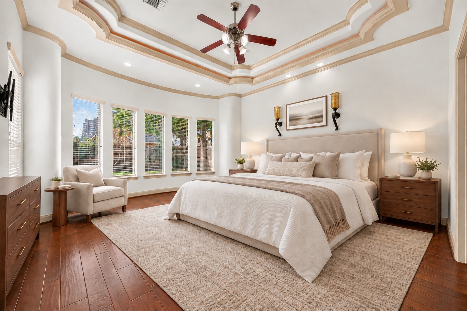 Spacious bedroom with elegant tray ceiling, large windows for natural light, and a cozy seating area. Spacious bedroom with elegant tray ceiling, large windows for natural light, and a cozy seating area.