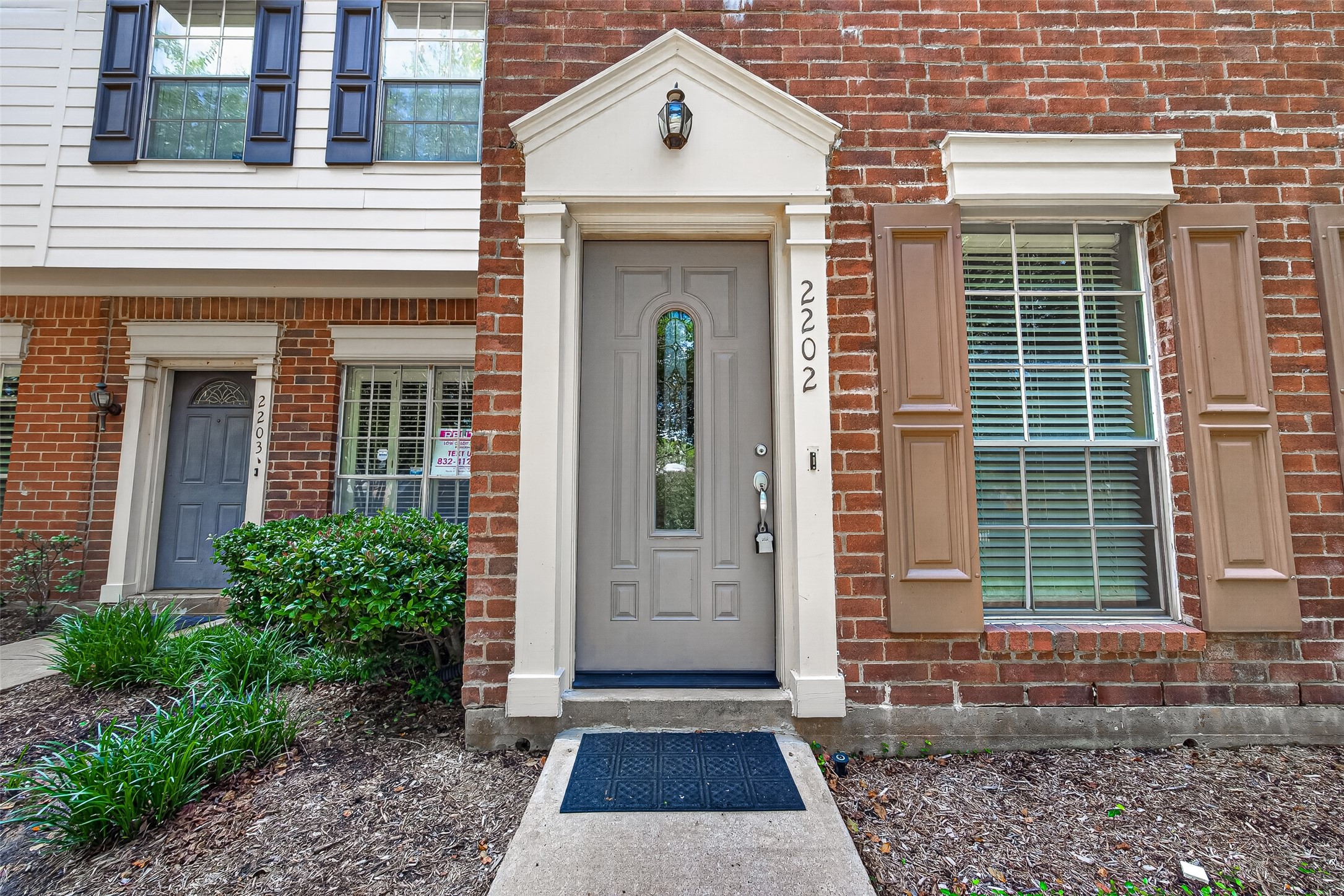 Welcoming private entrance framed by brick exterior, decorative trim, and mature landscaping. Welcoming private entrance framed by brick exterior, decorative trim, and mature landscaping.