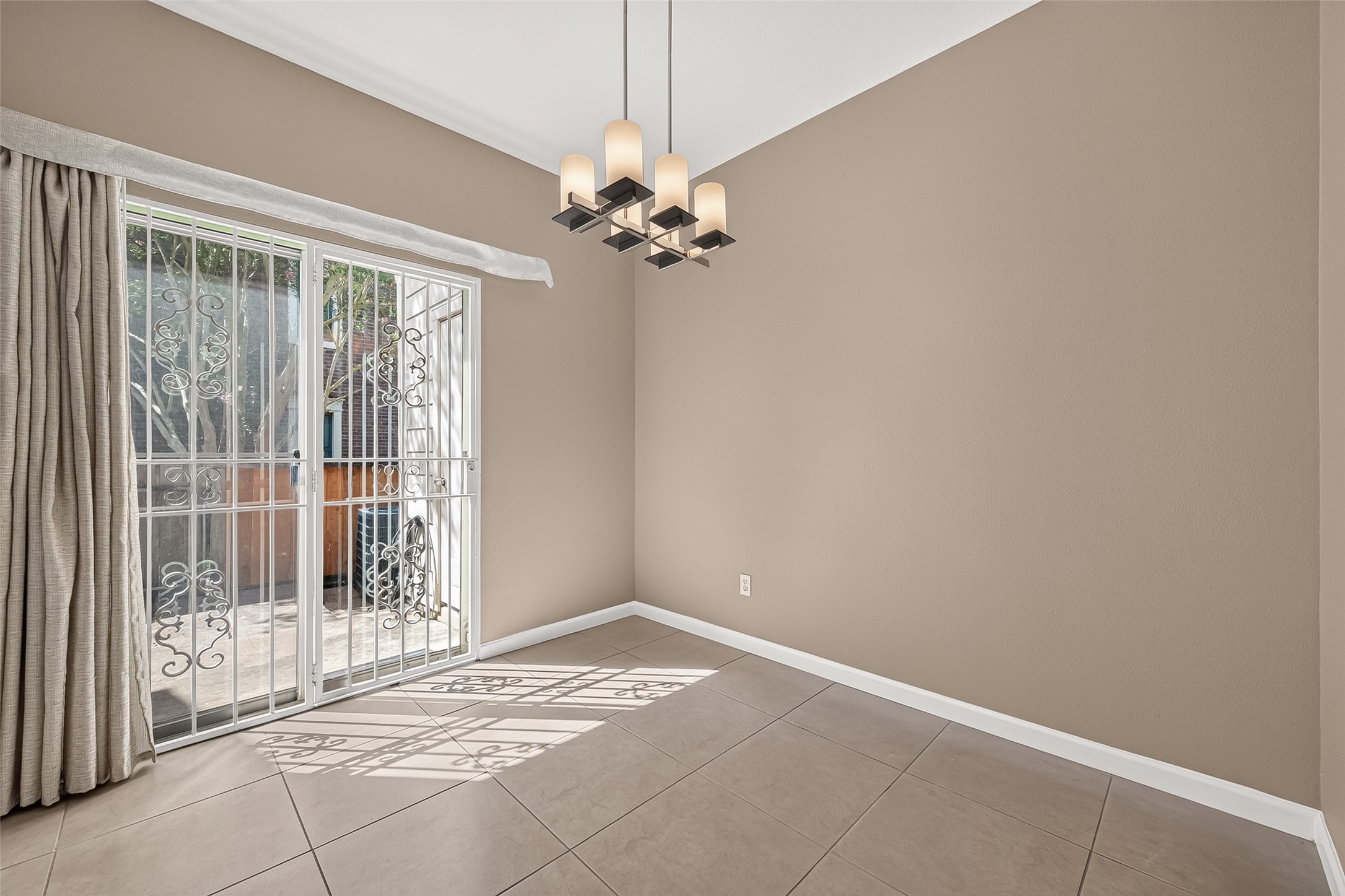 Light-filled dining space featuring contemporary lighting and direct access to the private outdoor patio.