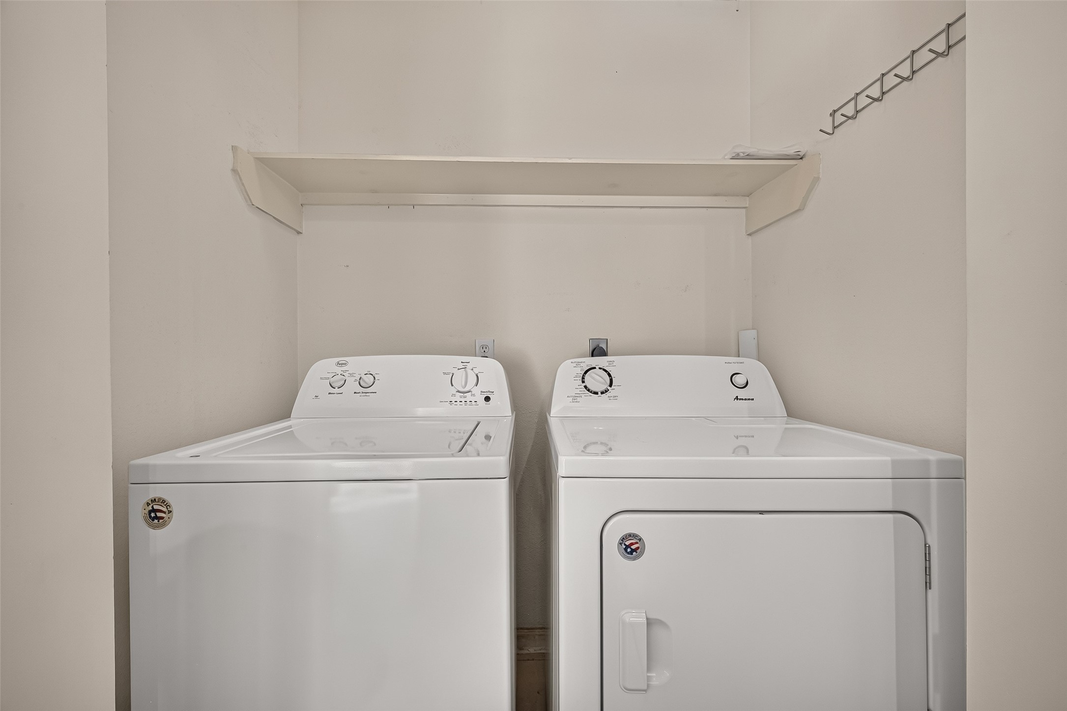 Convenient in-unit laundry area with full-size washer and dryer and overhead storage shelf.