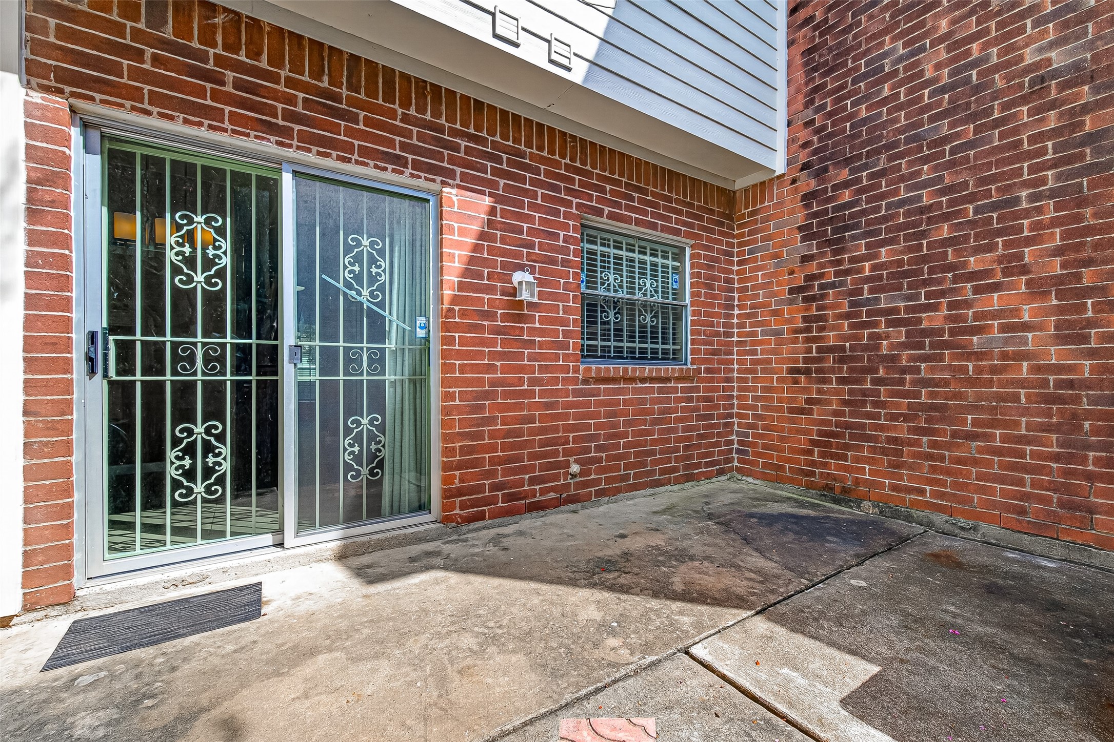 Enclosed brick patio conveniently accessed from the interior, offering a private outdoor space for relaxing, container gardening, or casual seating.