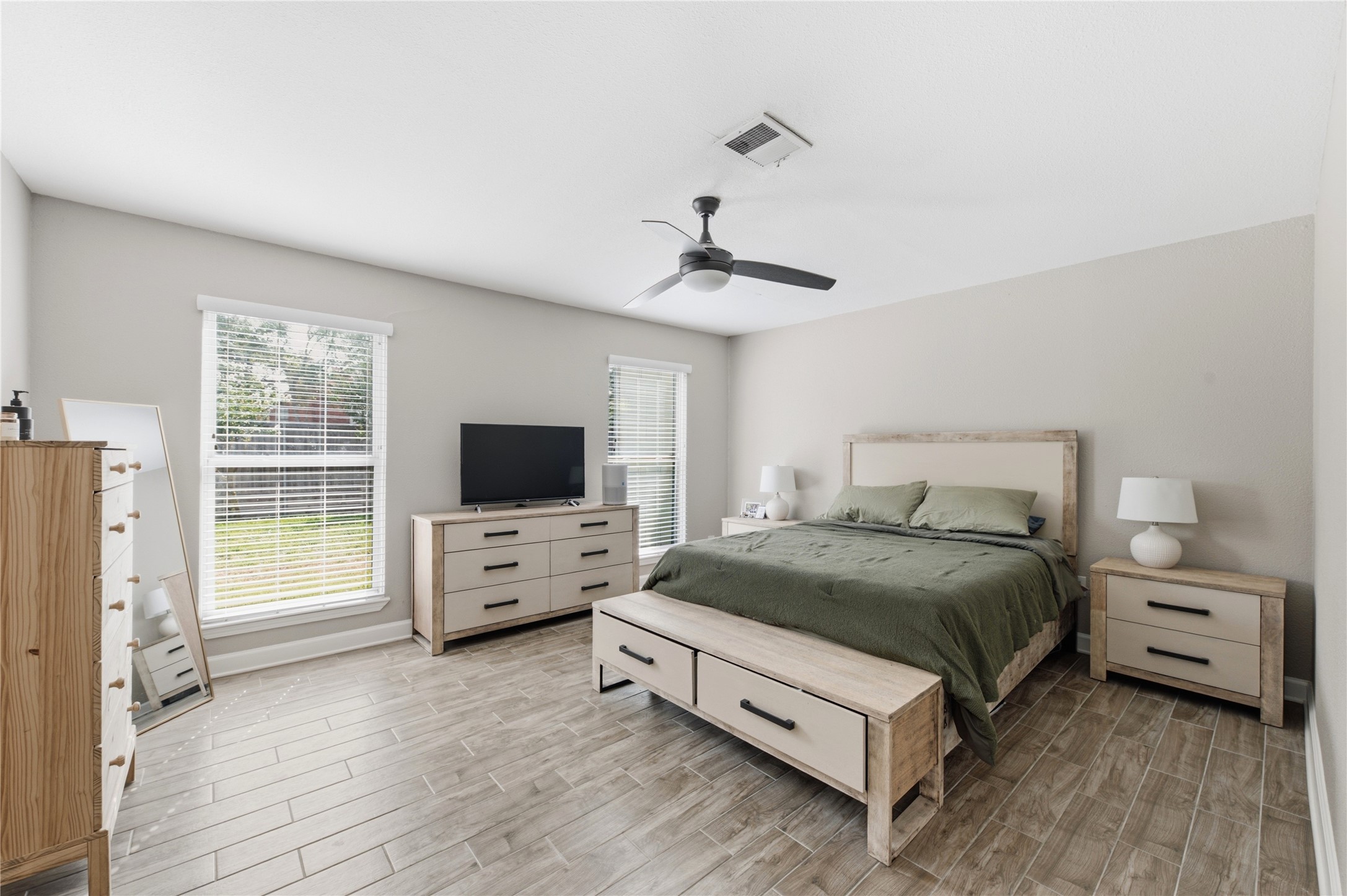 Spacious primary bedroom retreat with bright windows.