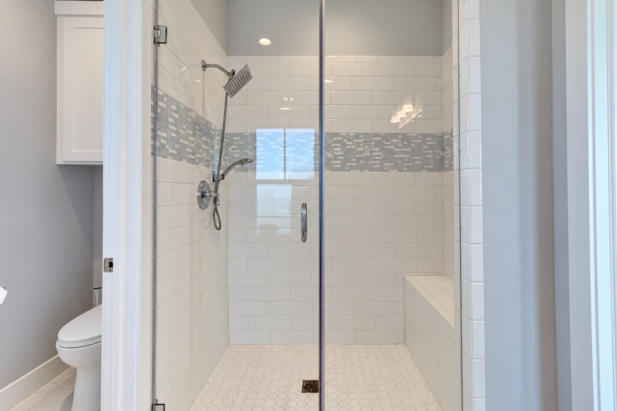 The primary bathroom has an oversized tile surround shower with glass enclosure.