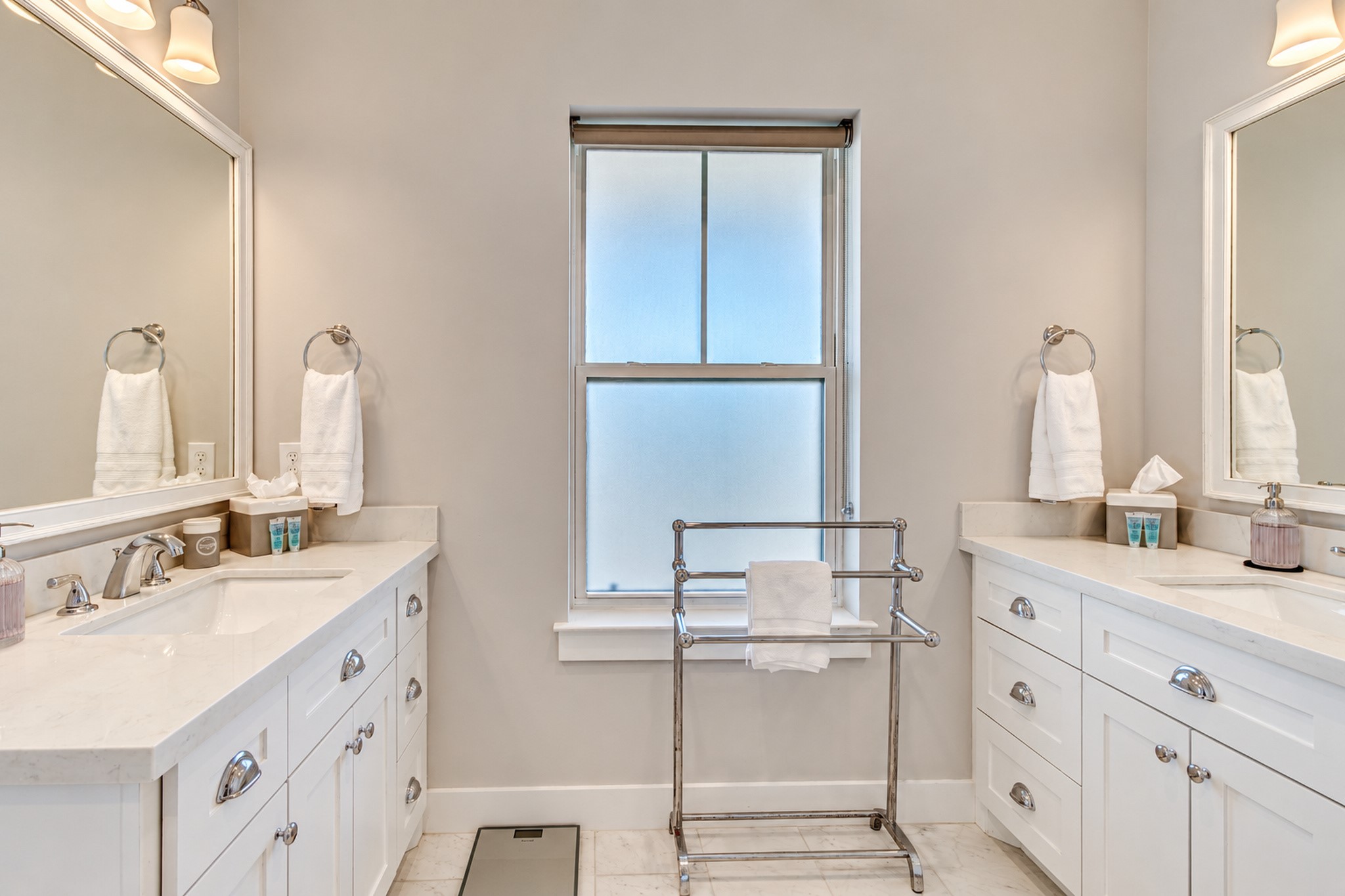 The primary bathroom featuring double quartz top vanitities.