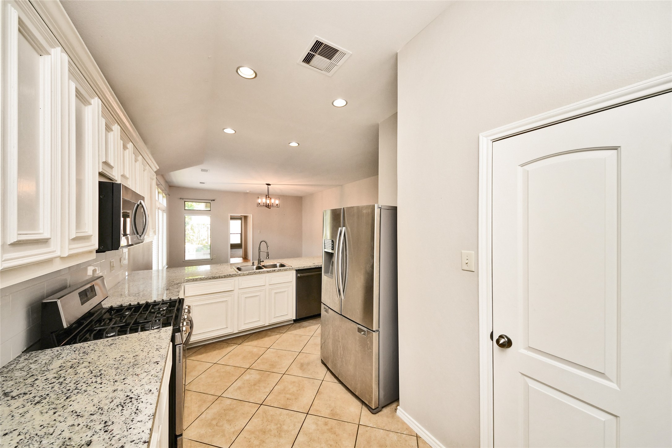 Modern kitchen with sleek granite countertops, stainless steel appliances, and ample cabinetry, offering a bright and functional space for culinary creations.