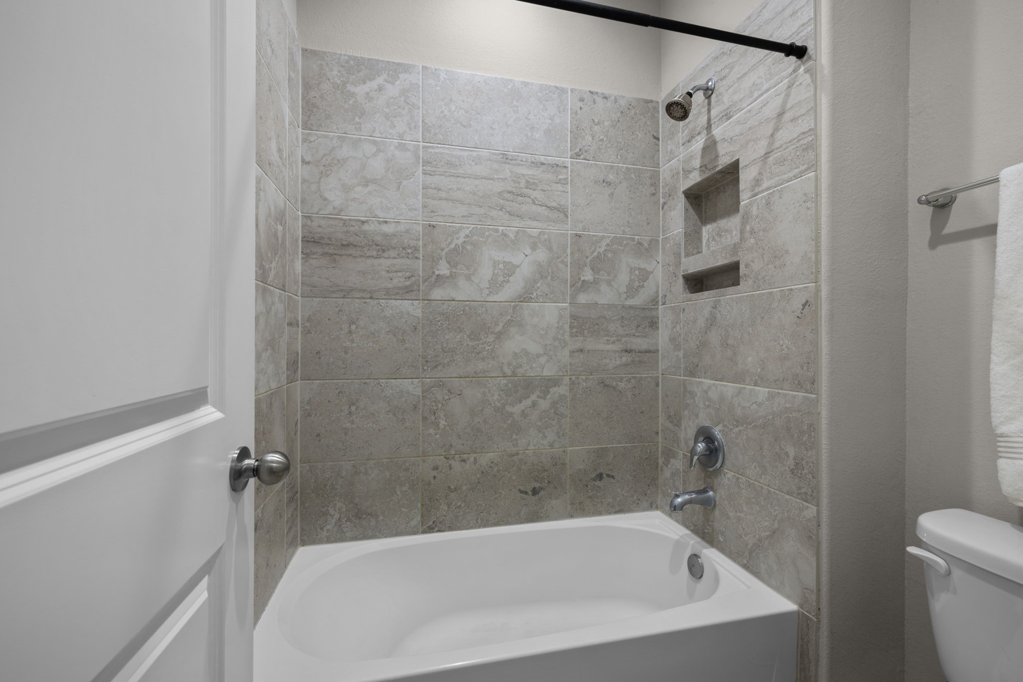 This bathroom has a tub/shower combo with full tile surround