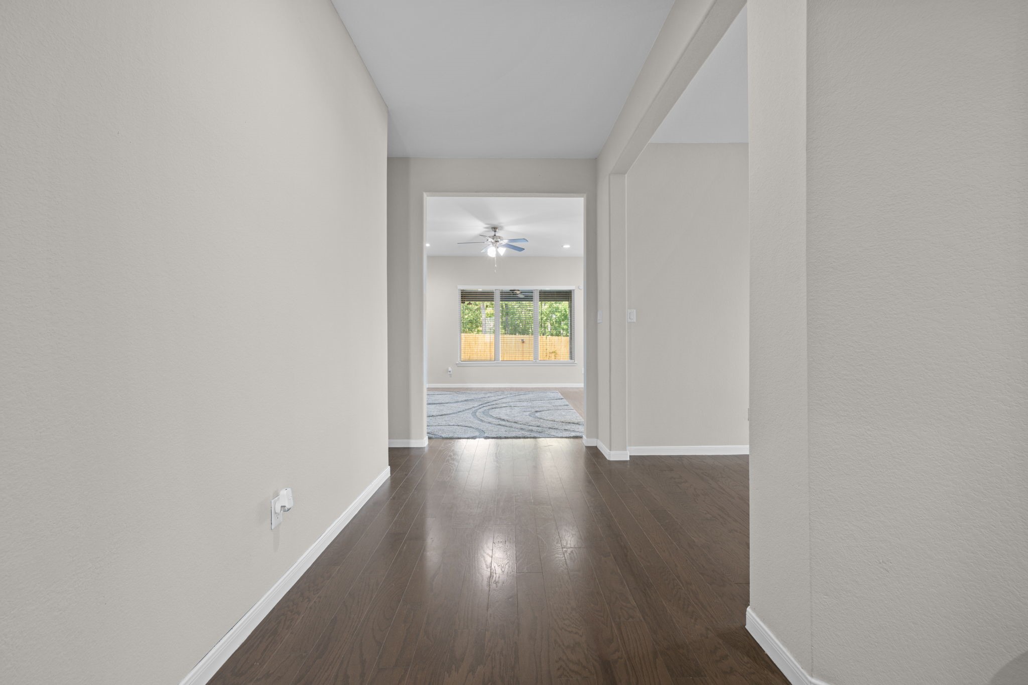 Looking from the front door down the wide foyer towards the family room area