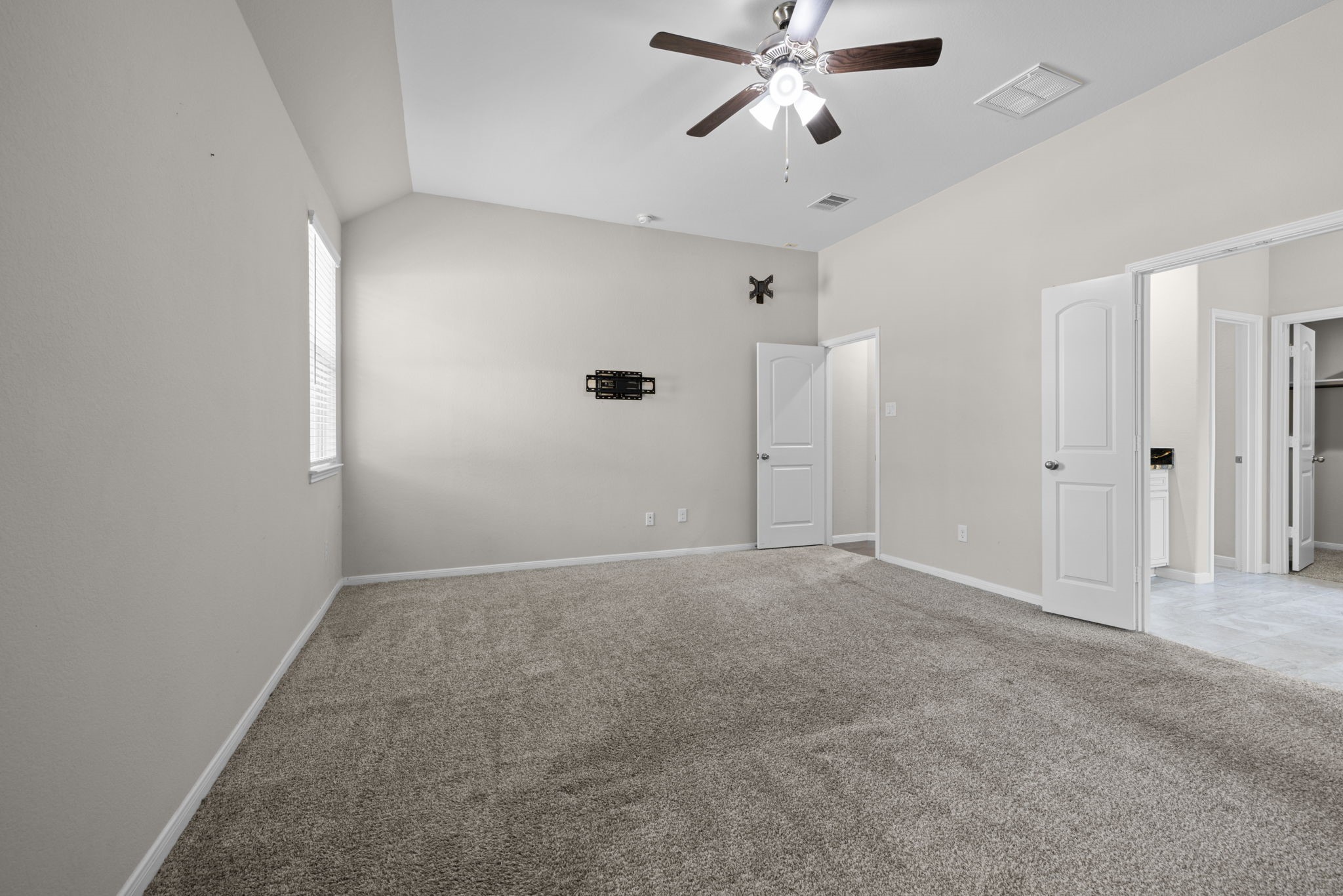 The spacious primary bedroom has high ceilings and ensuite bath