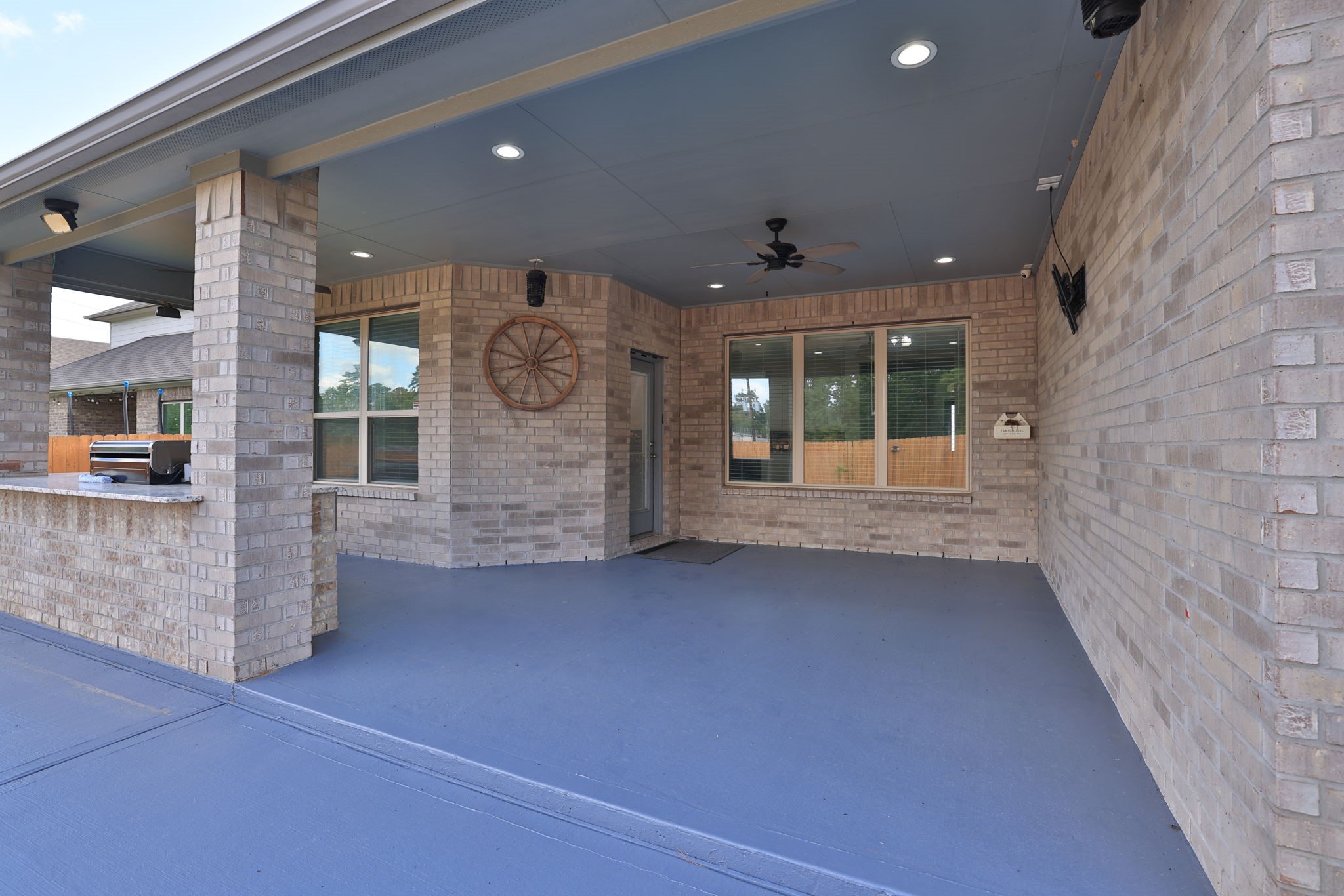 You'll truly enjoy this extended covered patio with ceiling fan and recently painted concrete floor.