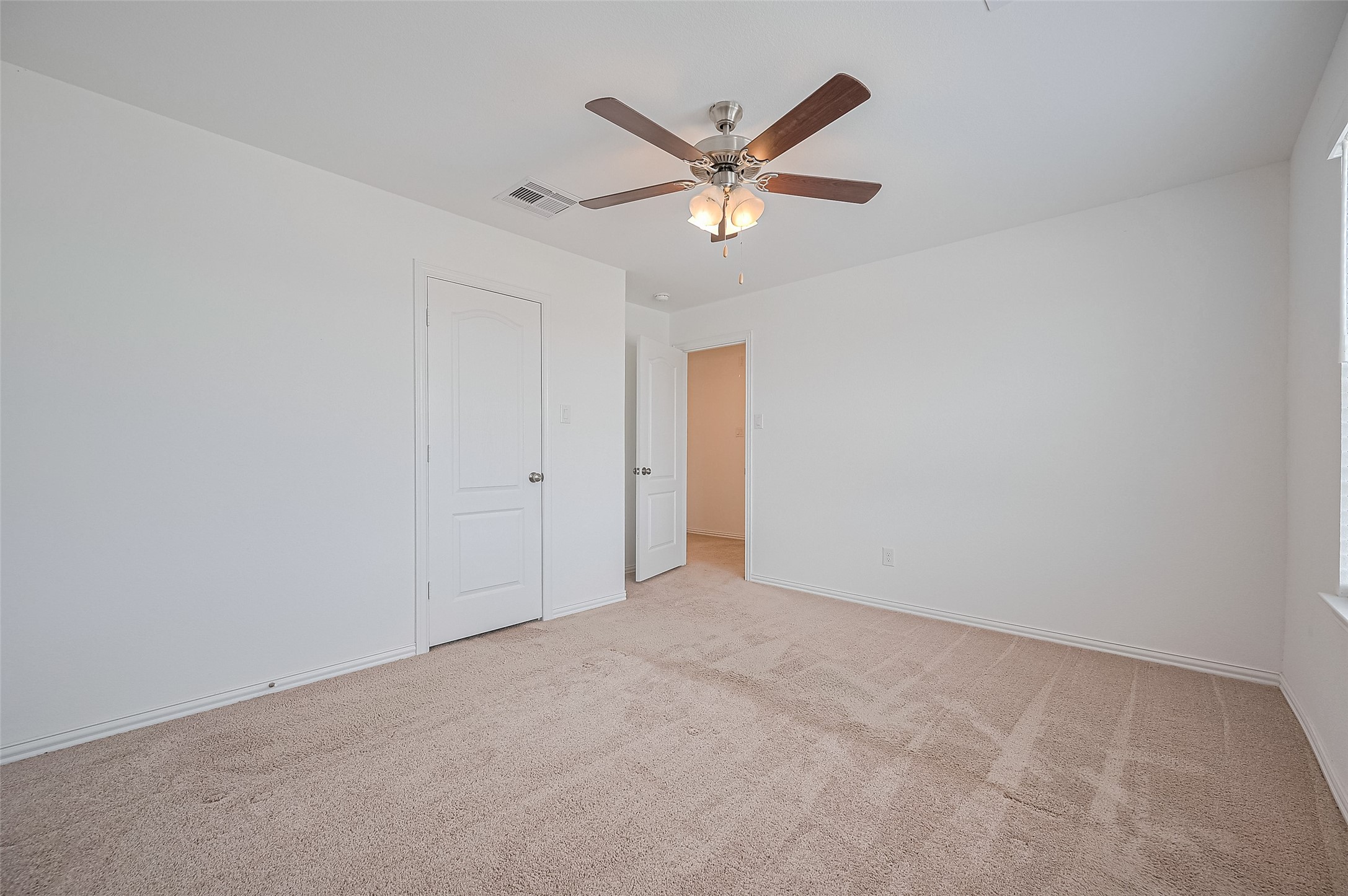 Room includes a ceiling fan with lights, creating a bright and airy space.