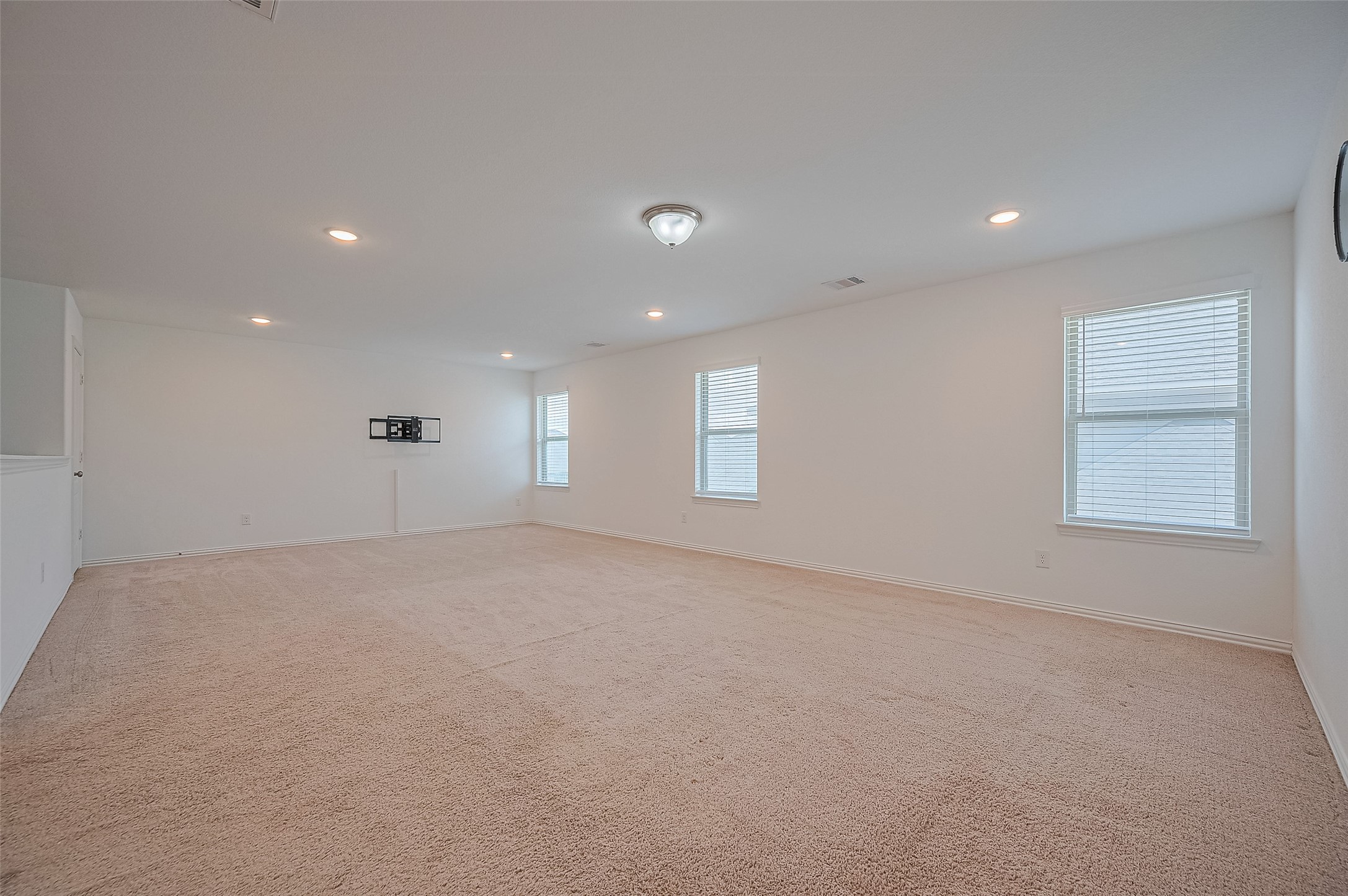 Family room with neutral carpeting and white walls.
