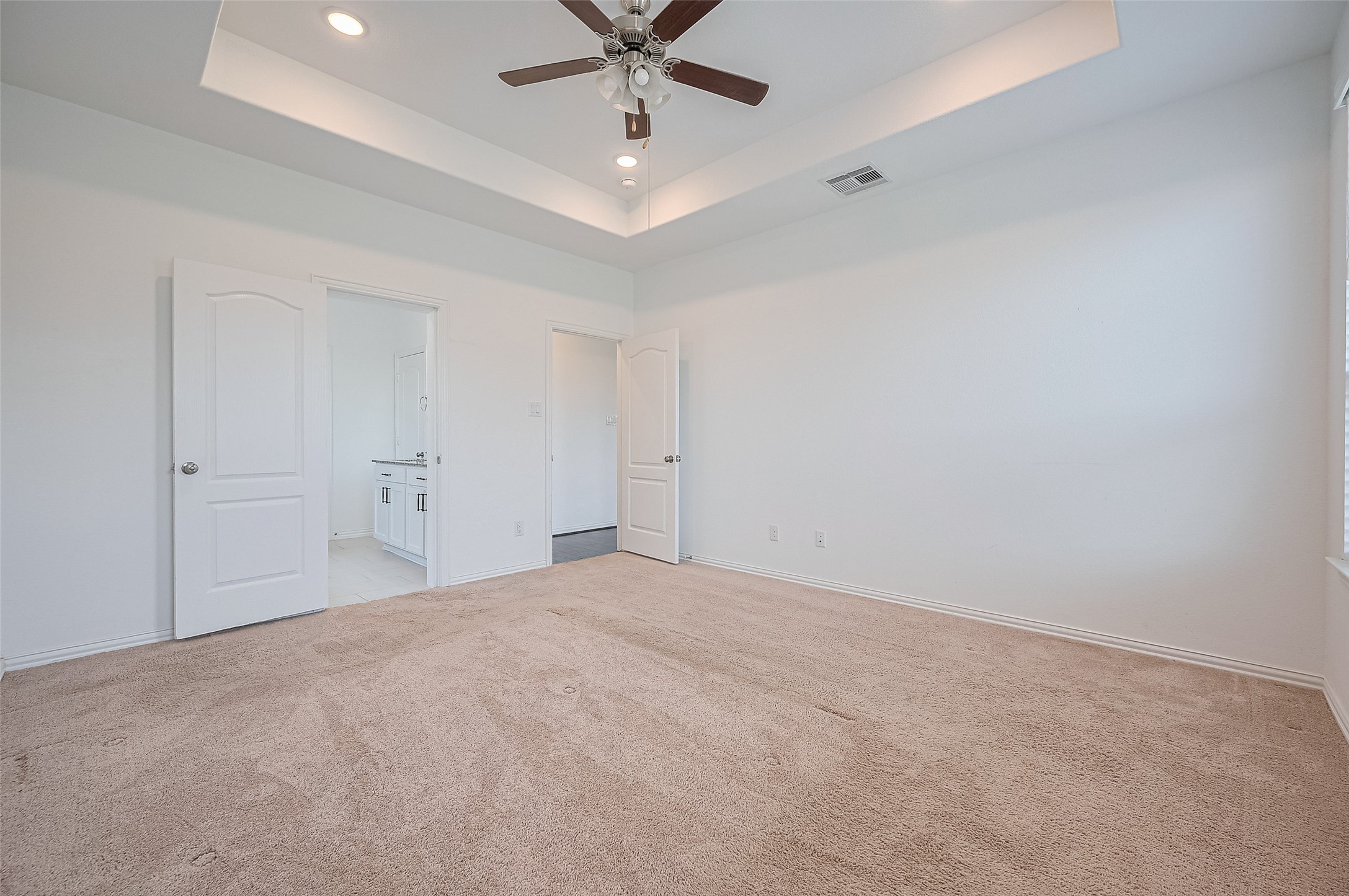 Room features two doorways leading to a bathroom and walk-in closet.