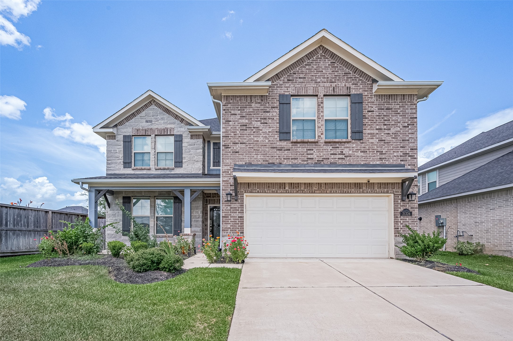 A two-story home with a two-car garage and a neatly landscaped front yard. A two-story home with a two-car garage and a neatly landscaped front yard.