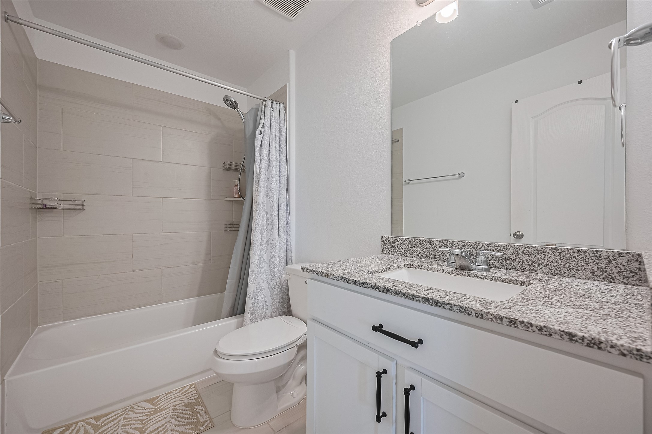 Bathroom features a modern design with sleek white cabinetry.