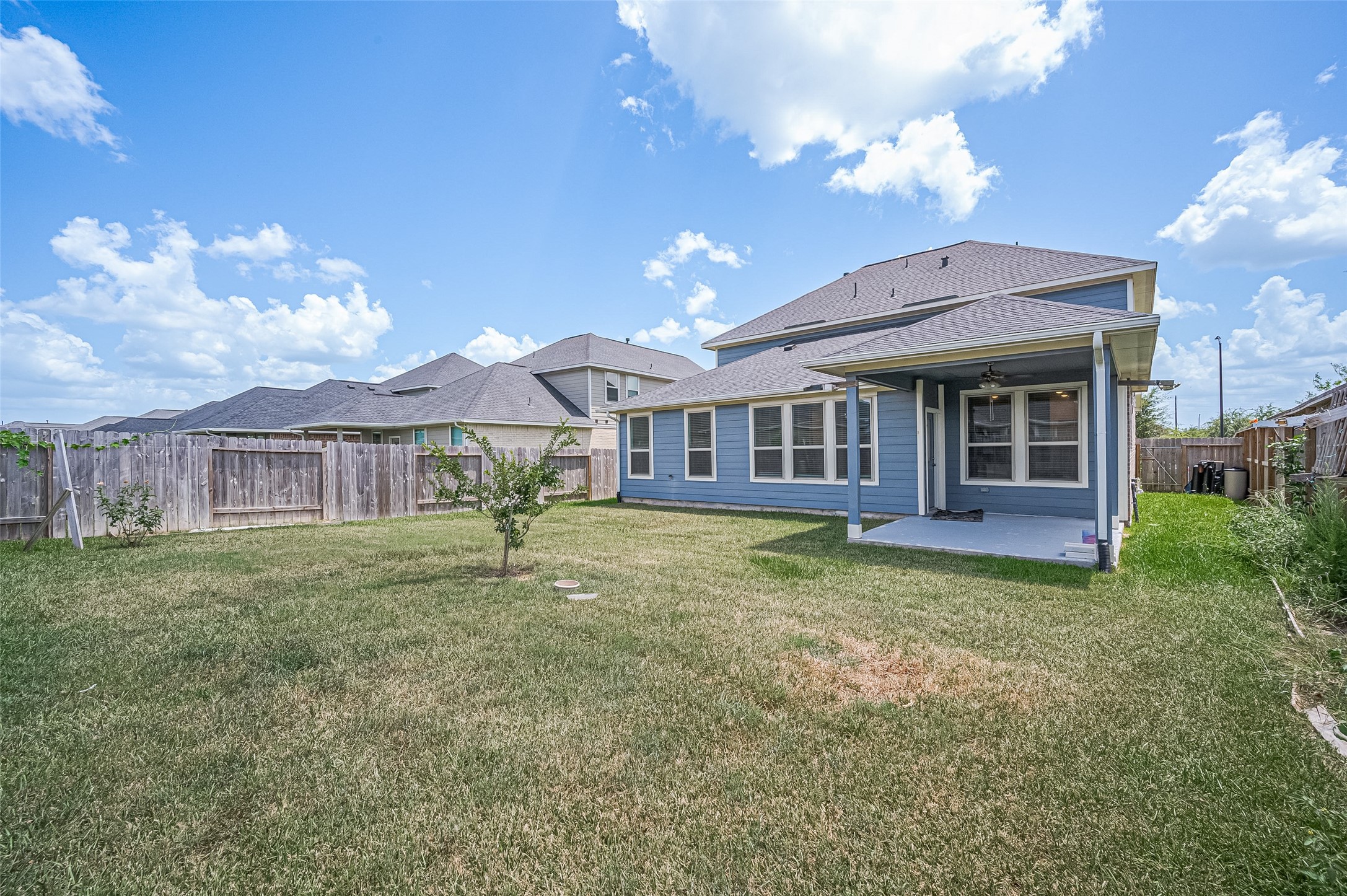 Backyard featuring a lush lawn and wooden privacy fence.