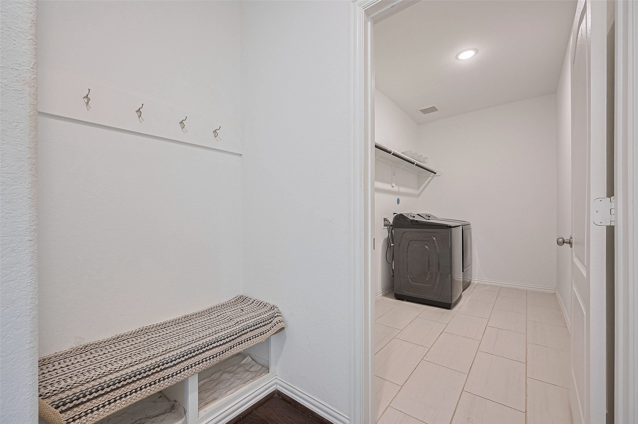 Laundry room featuring a modern washer, open shelving, and an adjoining mudroom.