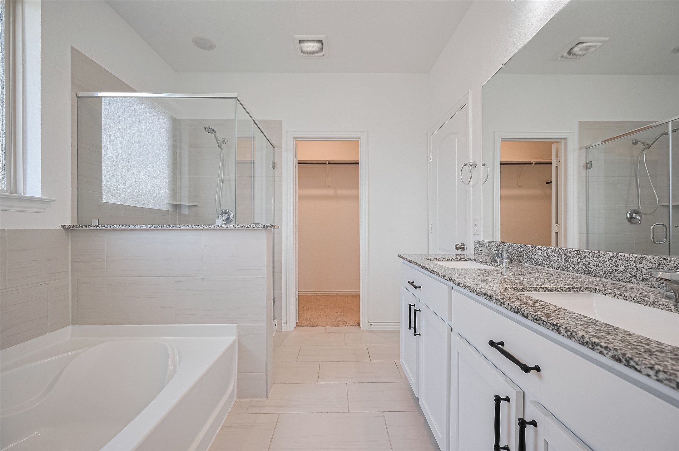 Primary bathroom features a spacious dual sink vanity with granite countertops.