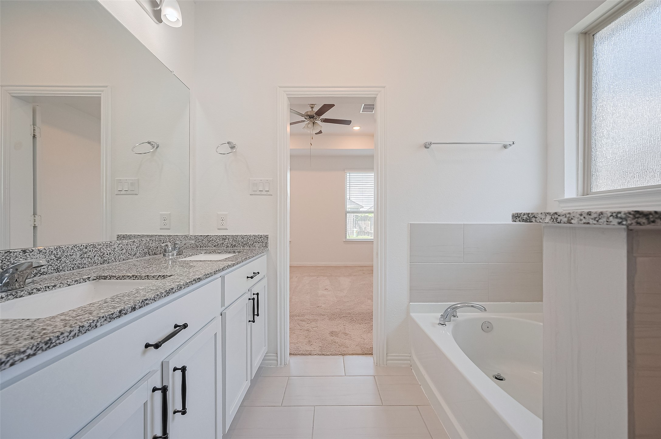 Bright bathroom features a recessed lighting and a large mirror.