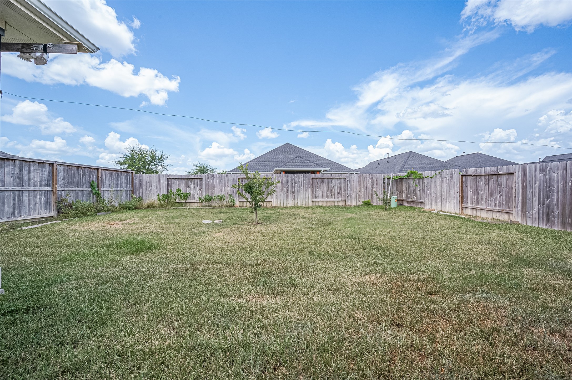 Expansive backyard with a pristine lawn and wooden fence.
