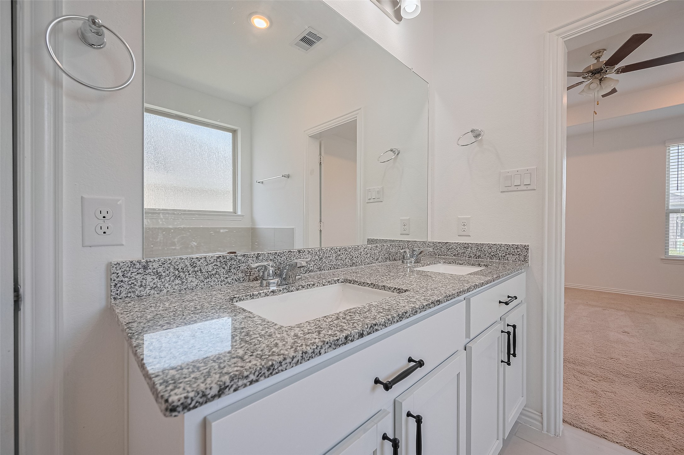 A dual sink vanity with ample storage and a large mirror.