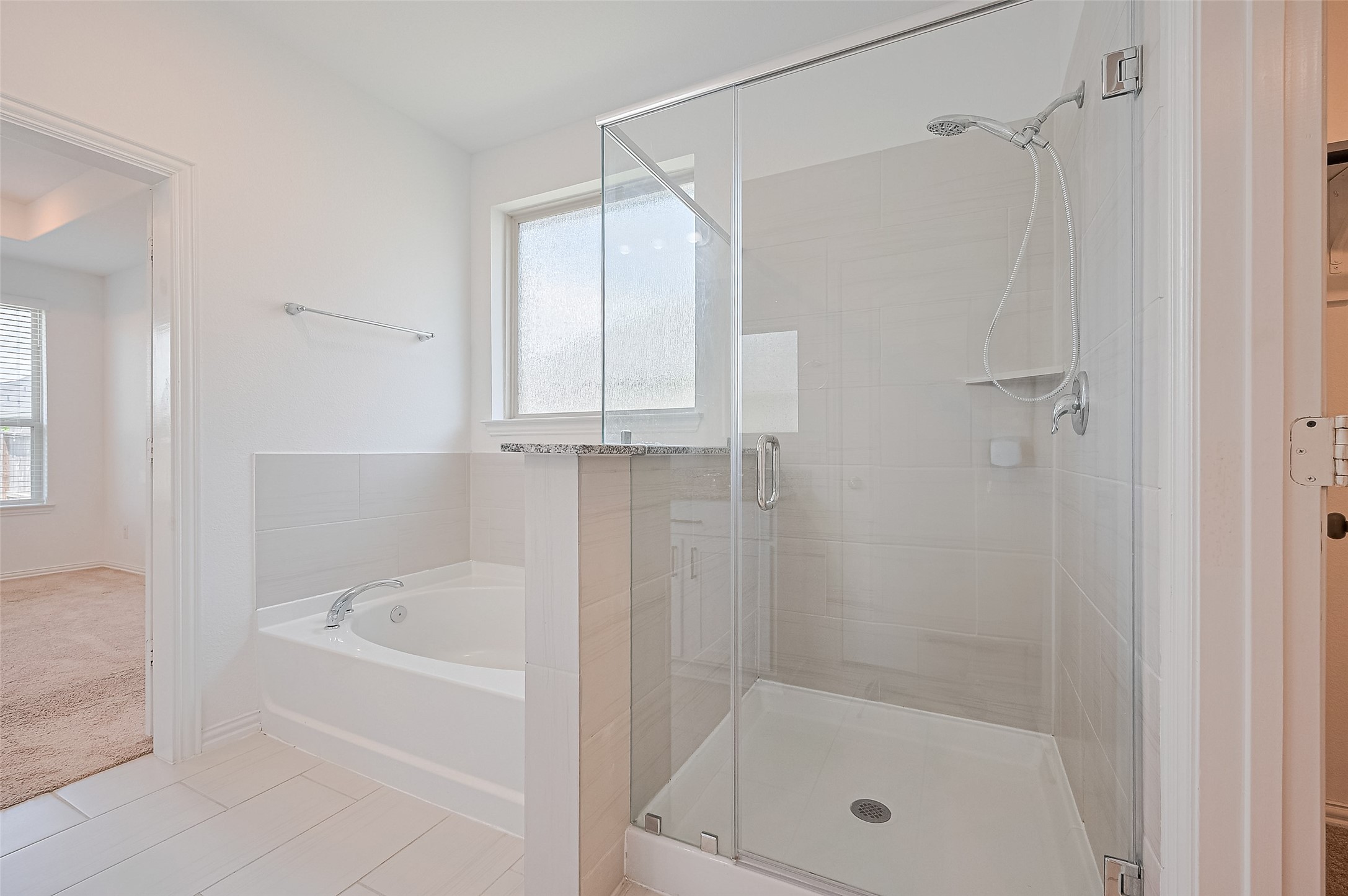 A spacious glass-enclosed shower and a separate soaking tub.