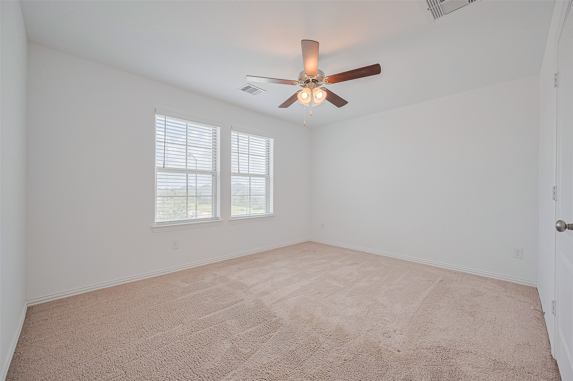 Bedroom with clean white walls and soft carpet flooring.