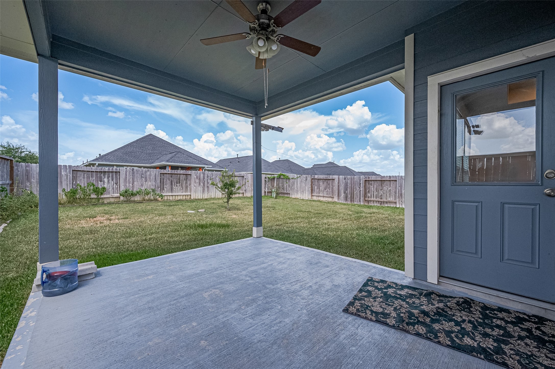 Charming covered patio with a ceiling fan.