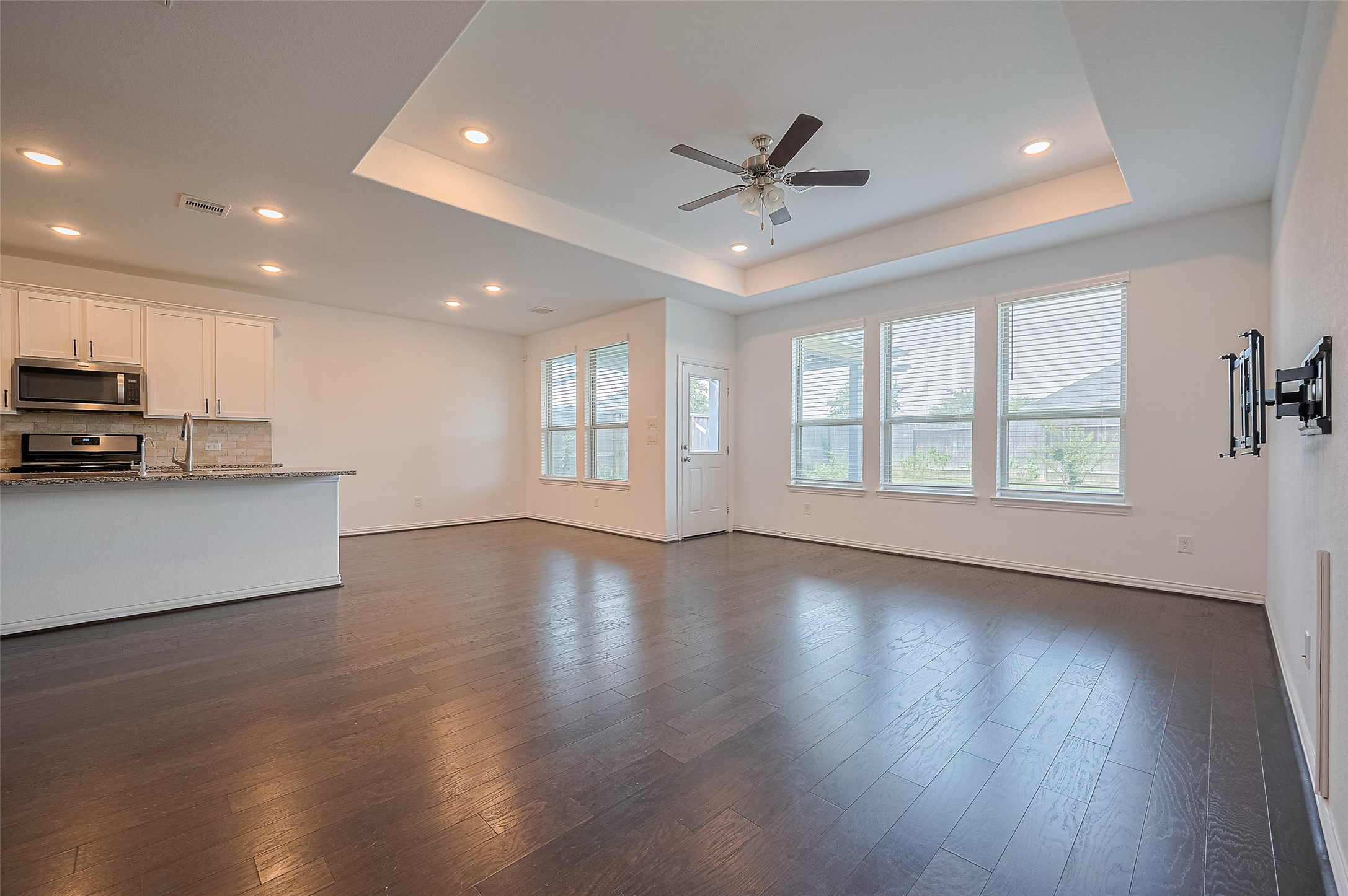 Open-concept living room with, a ceiling fan and a door leading to the backyard. Open-concept living room with, a ceiling fan and a door leading to the backyard.