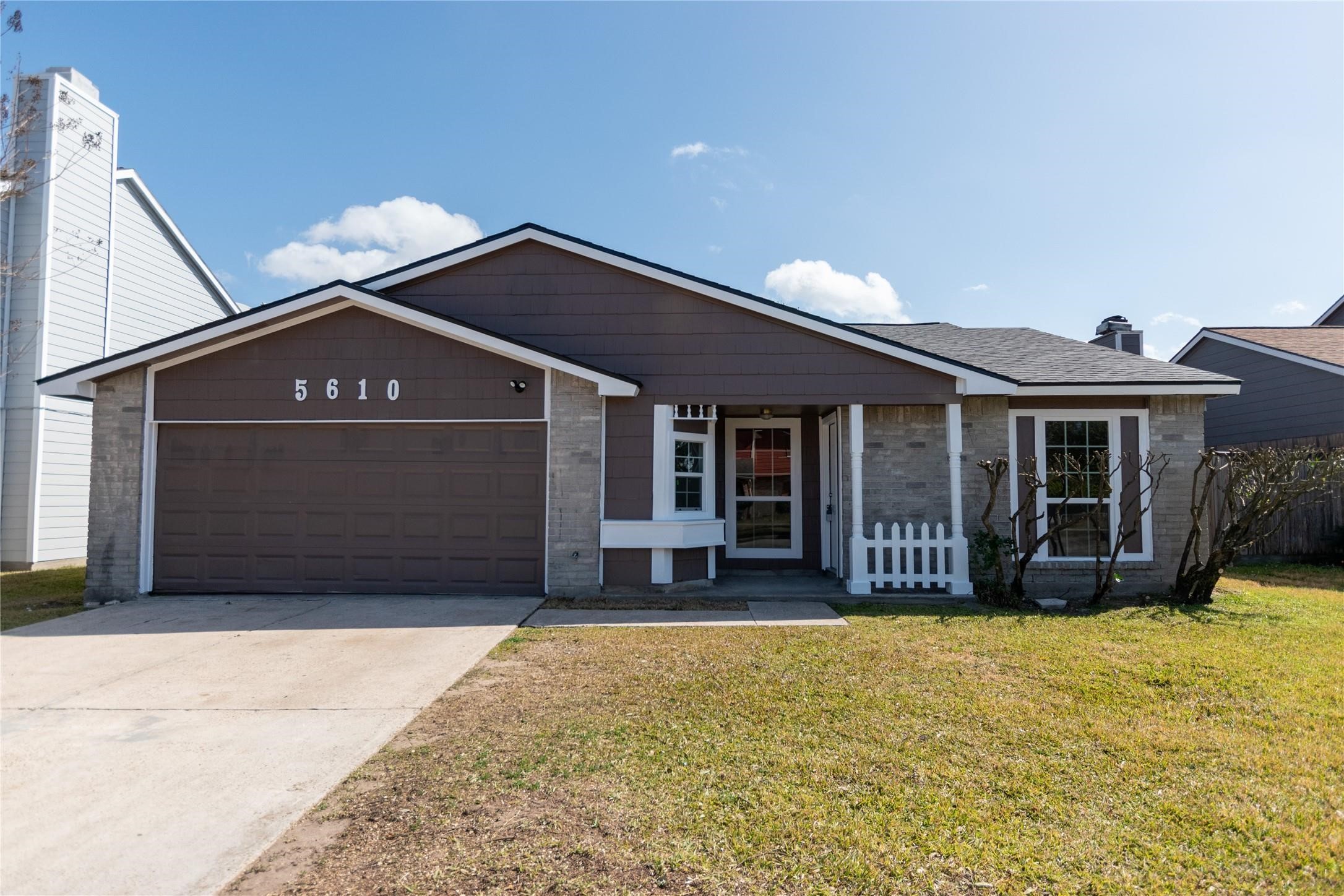 Charming single-story home with a welcoming facade, featuring a spacious two-car garage and well-maintained front yard.