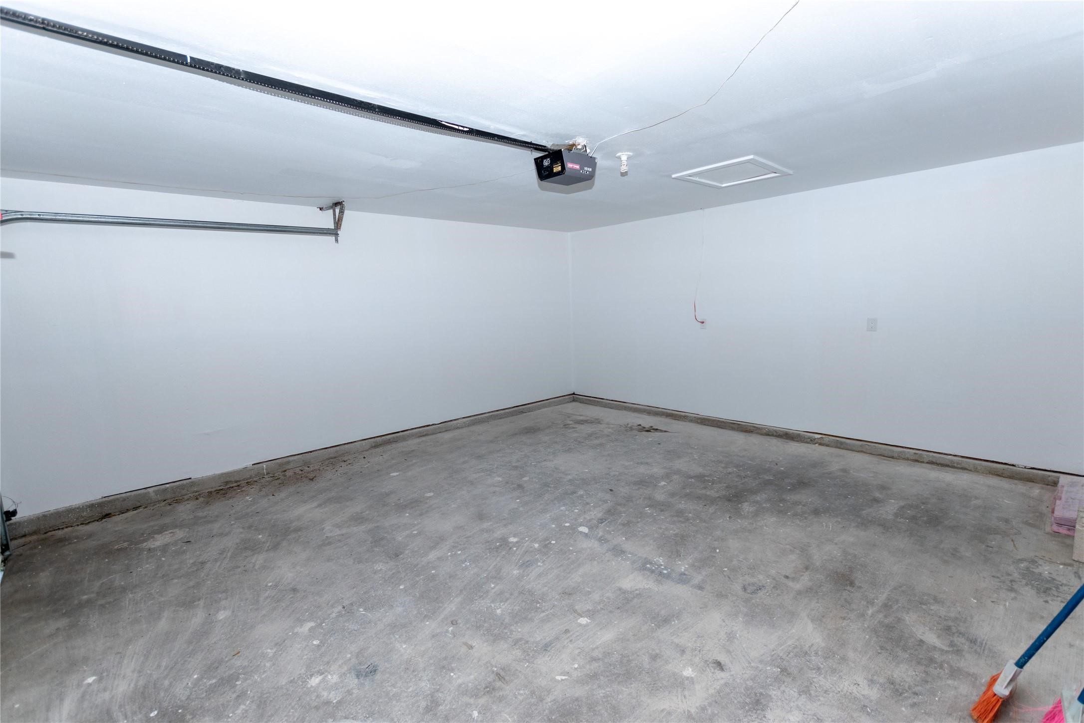 Spacious garage with clean, unfinished concrete flooring and ample room for storage or parking.