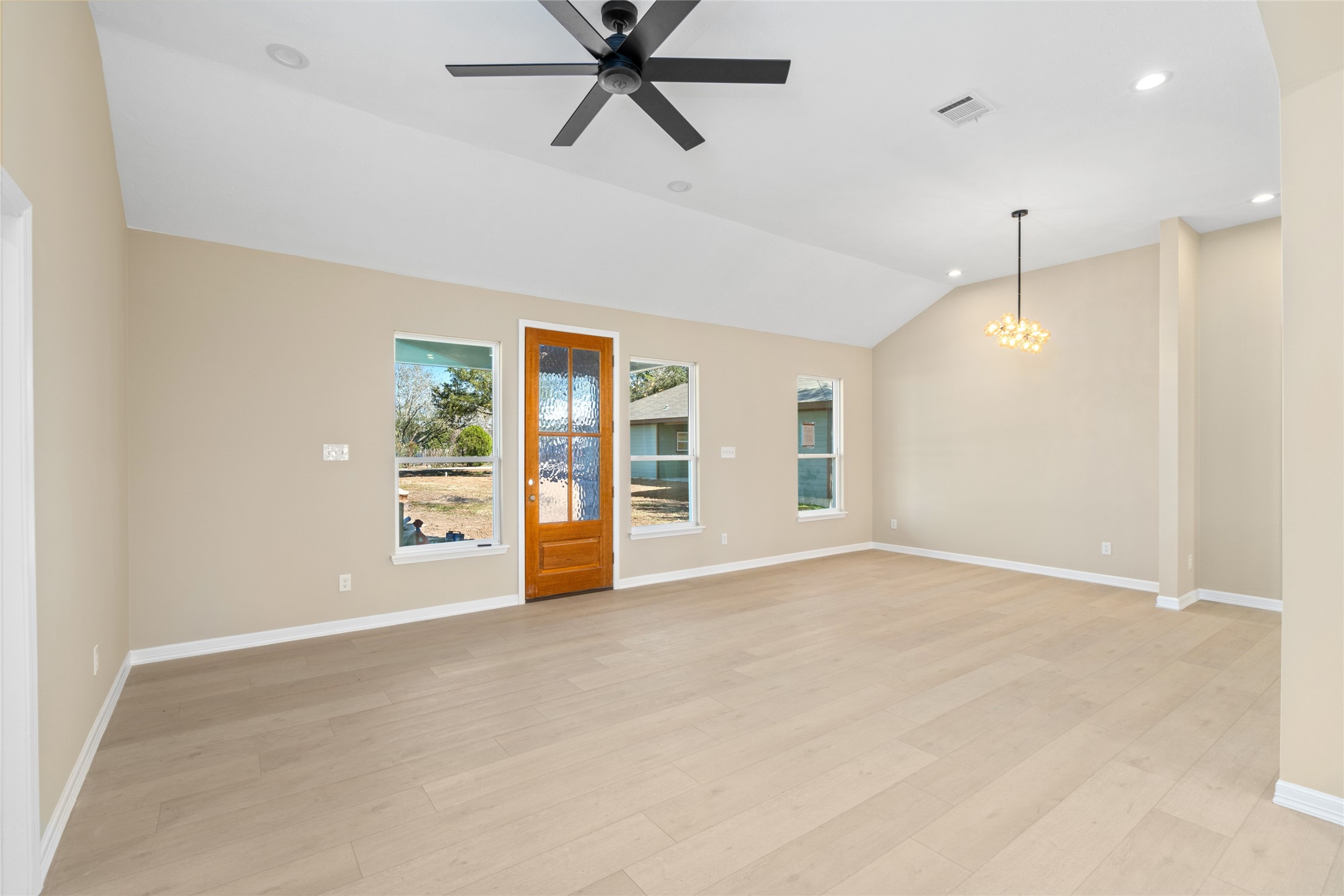 Step into a sun-filled living
area with vaulted ceilings,
sleek recessed lighting, and a
modern black ceiling fan.
Light hardwood floors and
neutral tones create an open,
inviting space perfect for
entertaining.