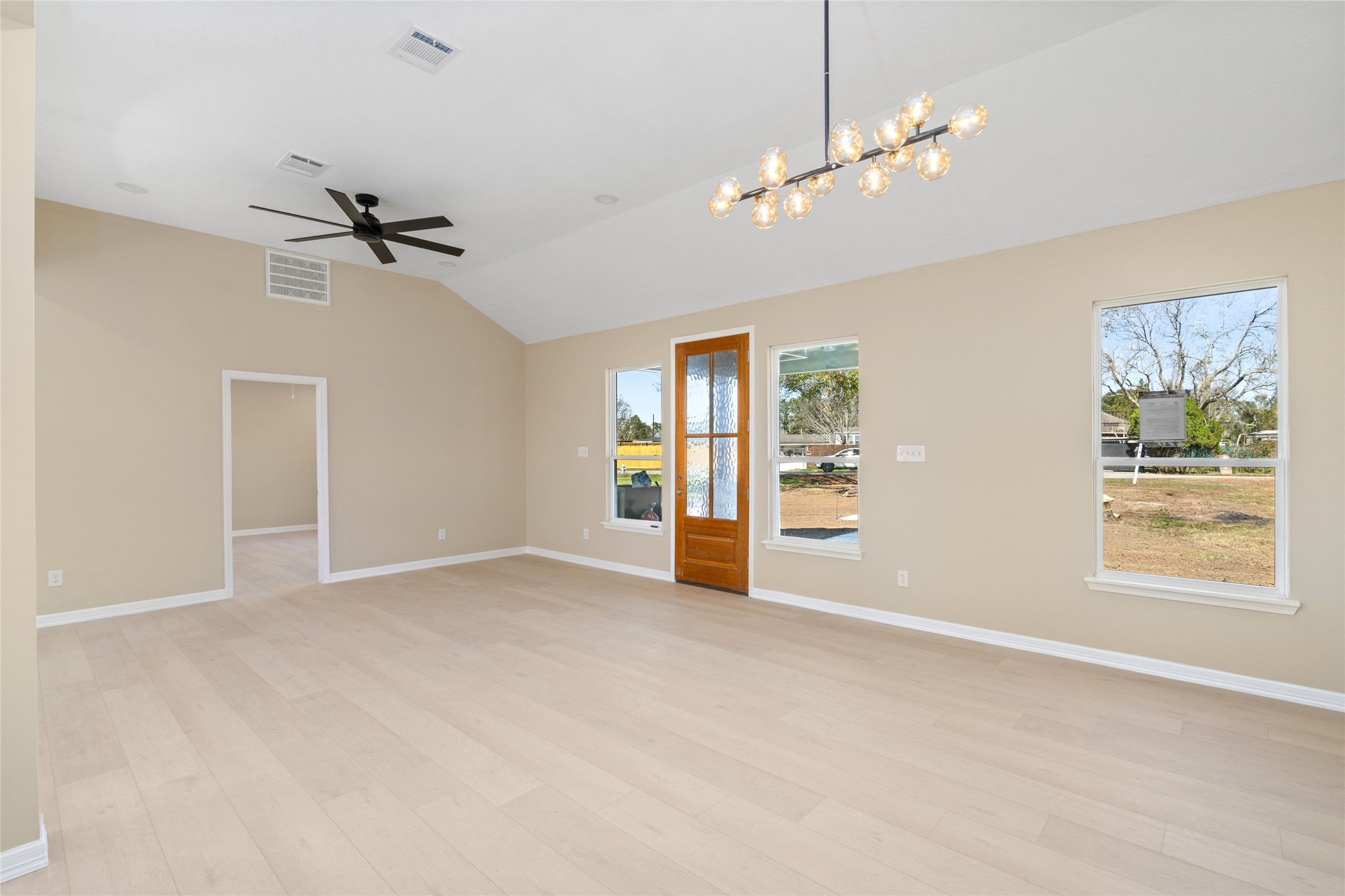Spacious, open-concept living
room with vaulted ceilings,
expansive windows, and a
stylish ceiling fan. This wideangle view showcases
seamless flow and room for
every lifestyle.