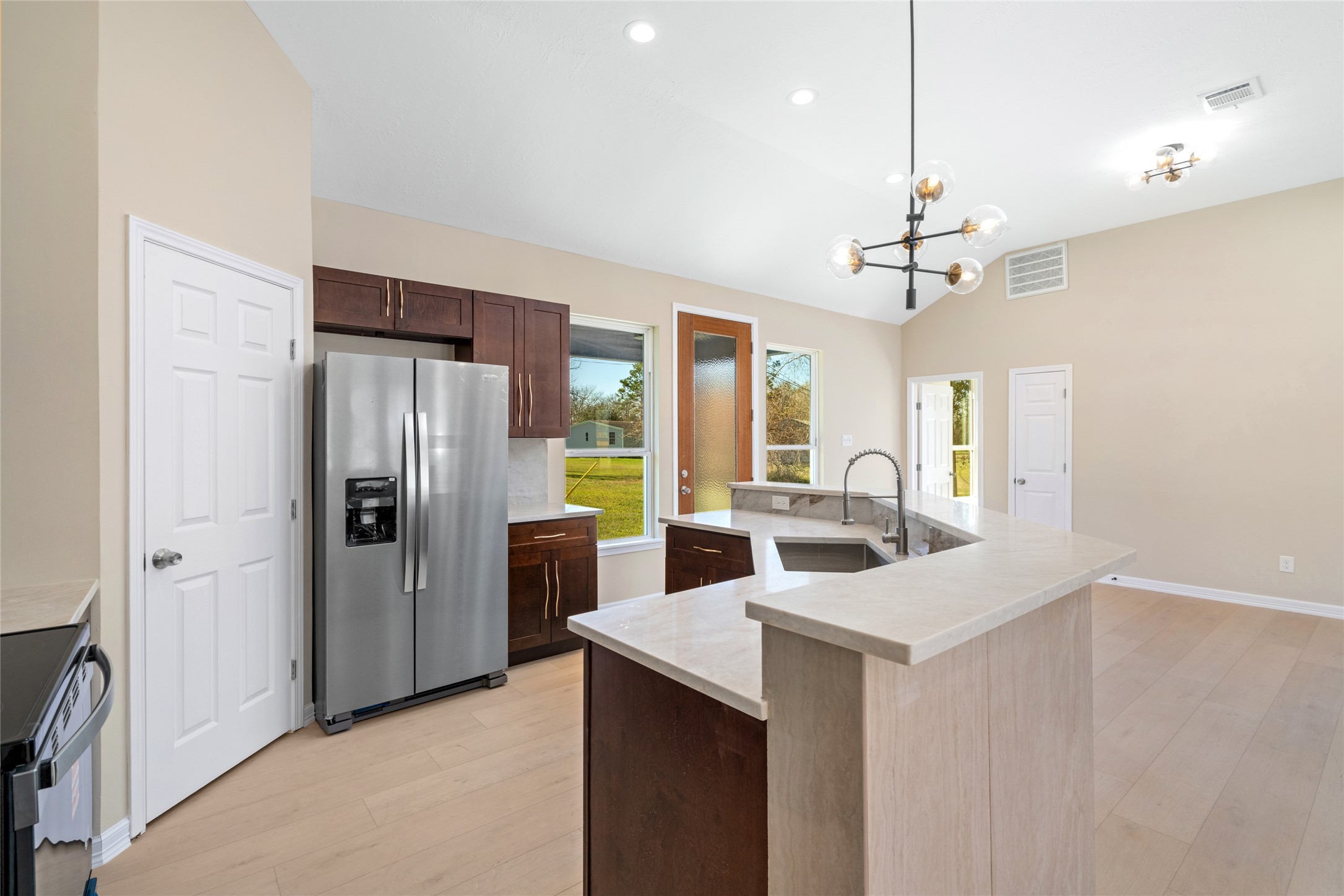 A wide-angle captures the full
kitchen layout, including
generous storage, elegant
finishes, and a seamless
connection to living and
dining areas.