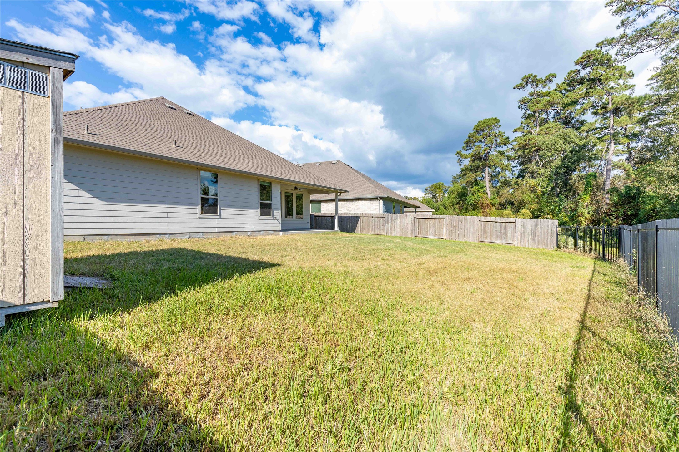 Expansive backyard with lush grass and privacy fencing, perfect for outdoor activities and relaxation.
