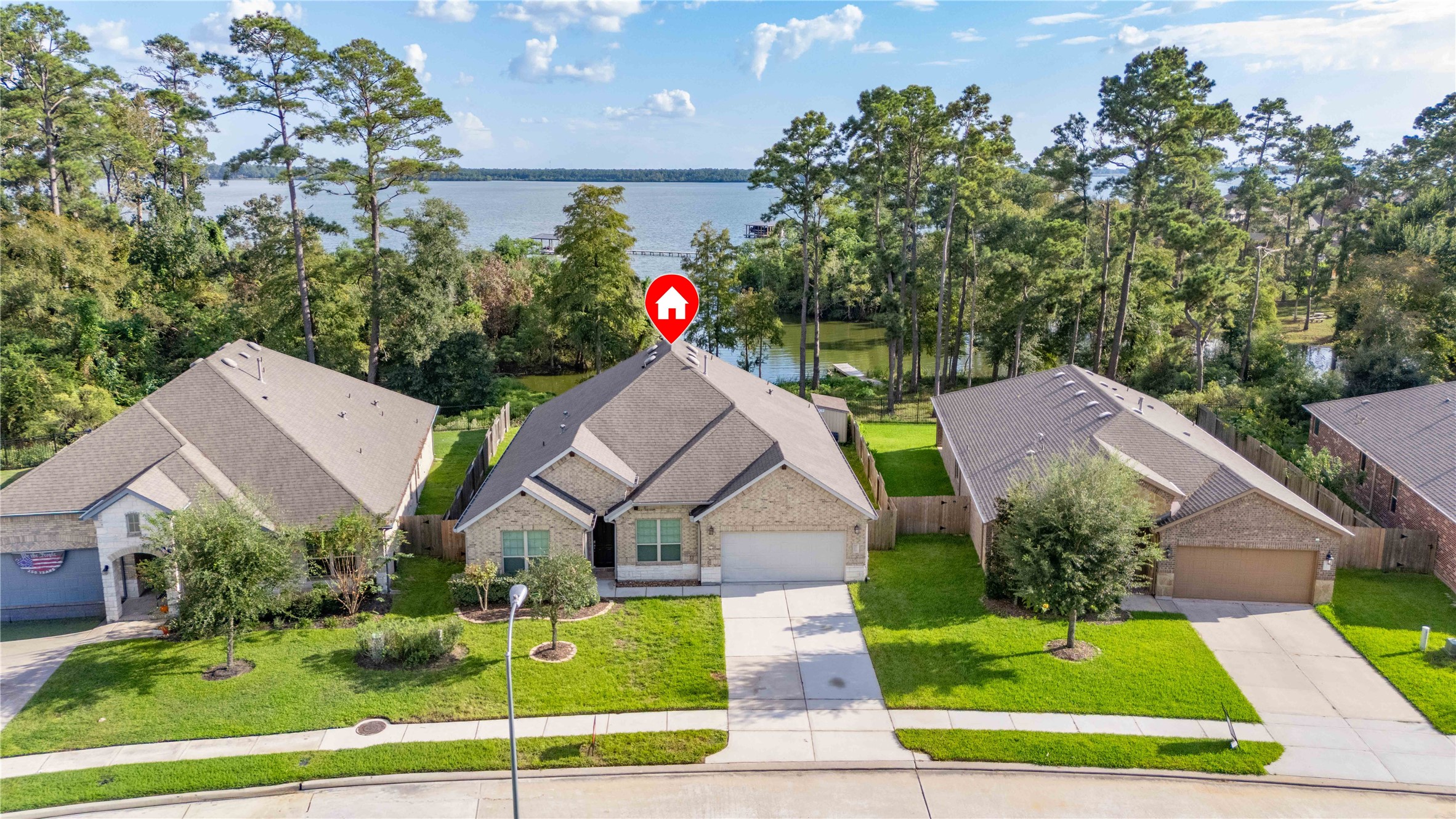 Charming single-story brick home with a well-maintained lawn, nestled in a serene neighborhood with picturesque lake views.