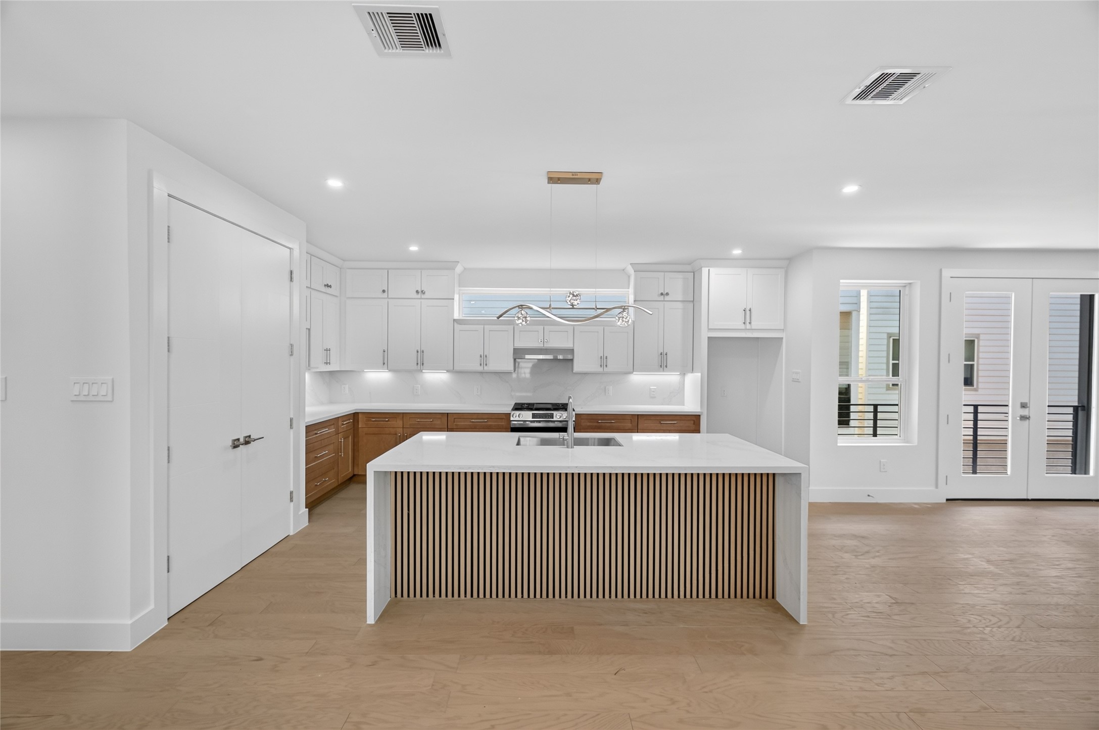 Spacious kitchen located on the second floor with waterfall island with acoustic panel, under cabinet lighting and brush nickel hardware